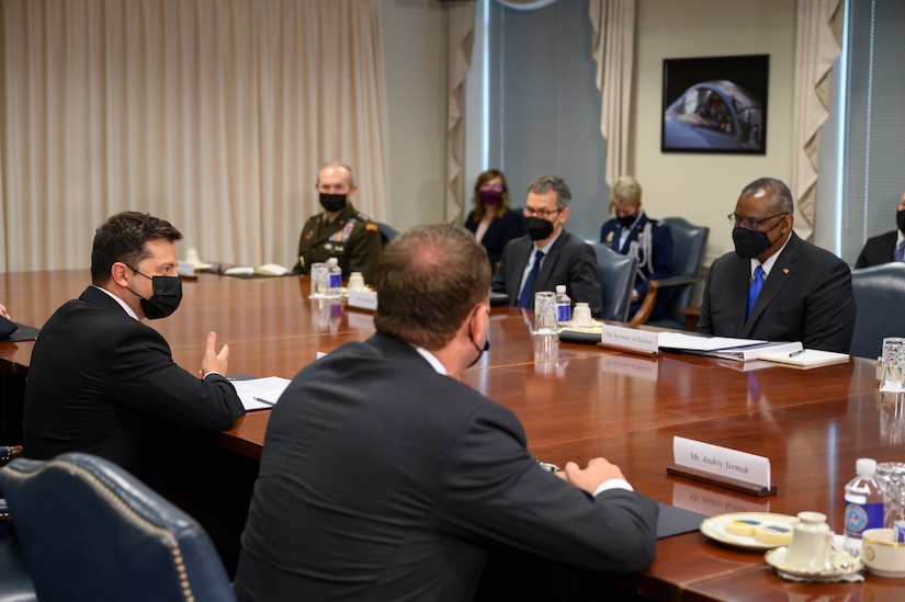 People wearing masks sit at a table.