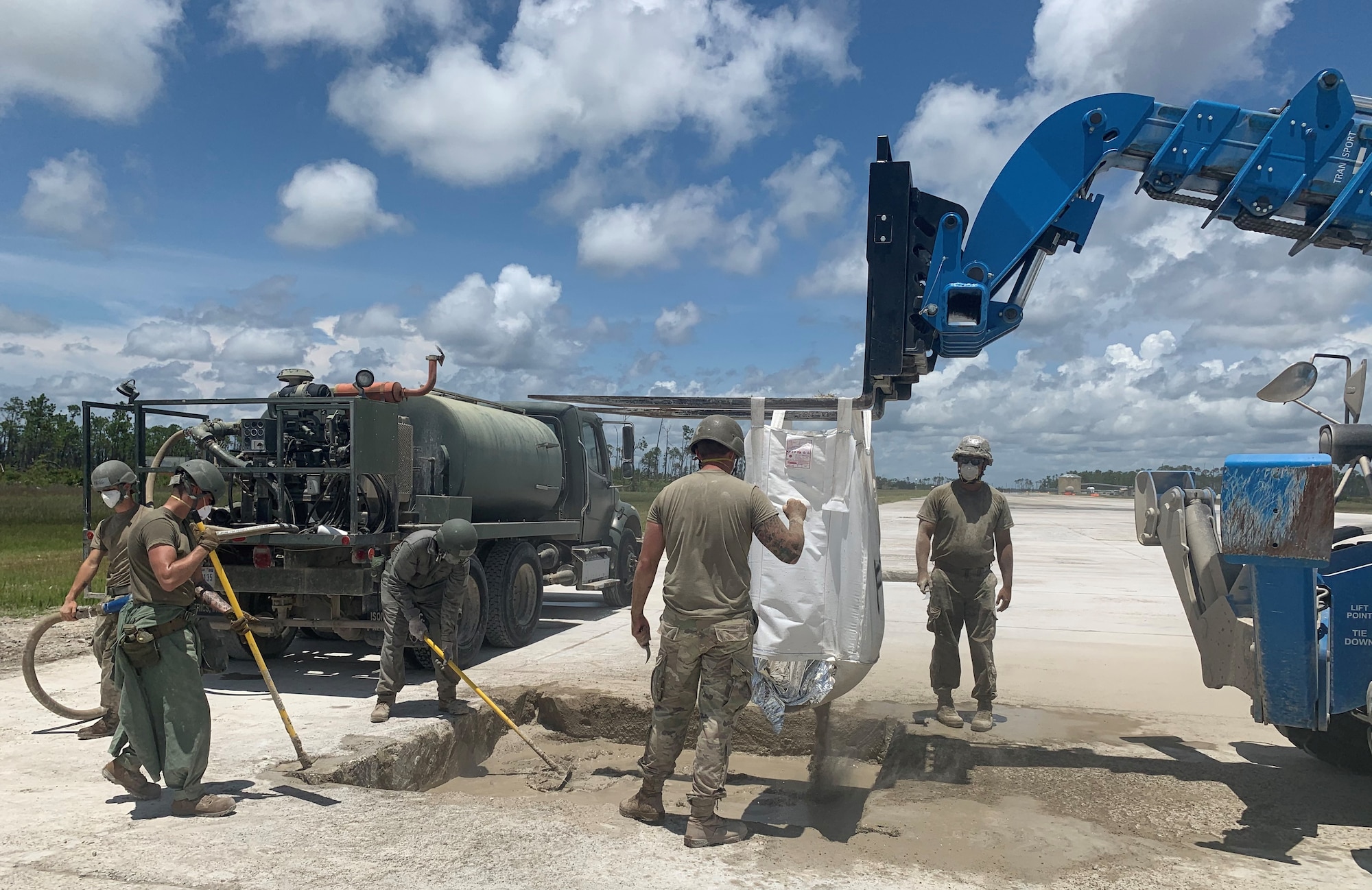 Airmen fill a crater on a runway