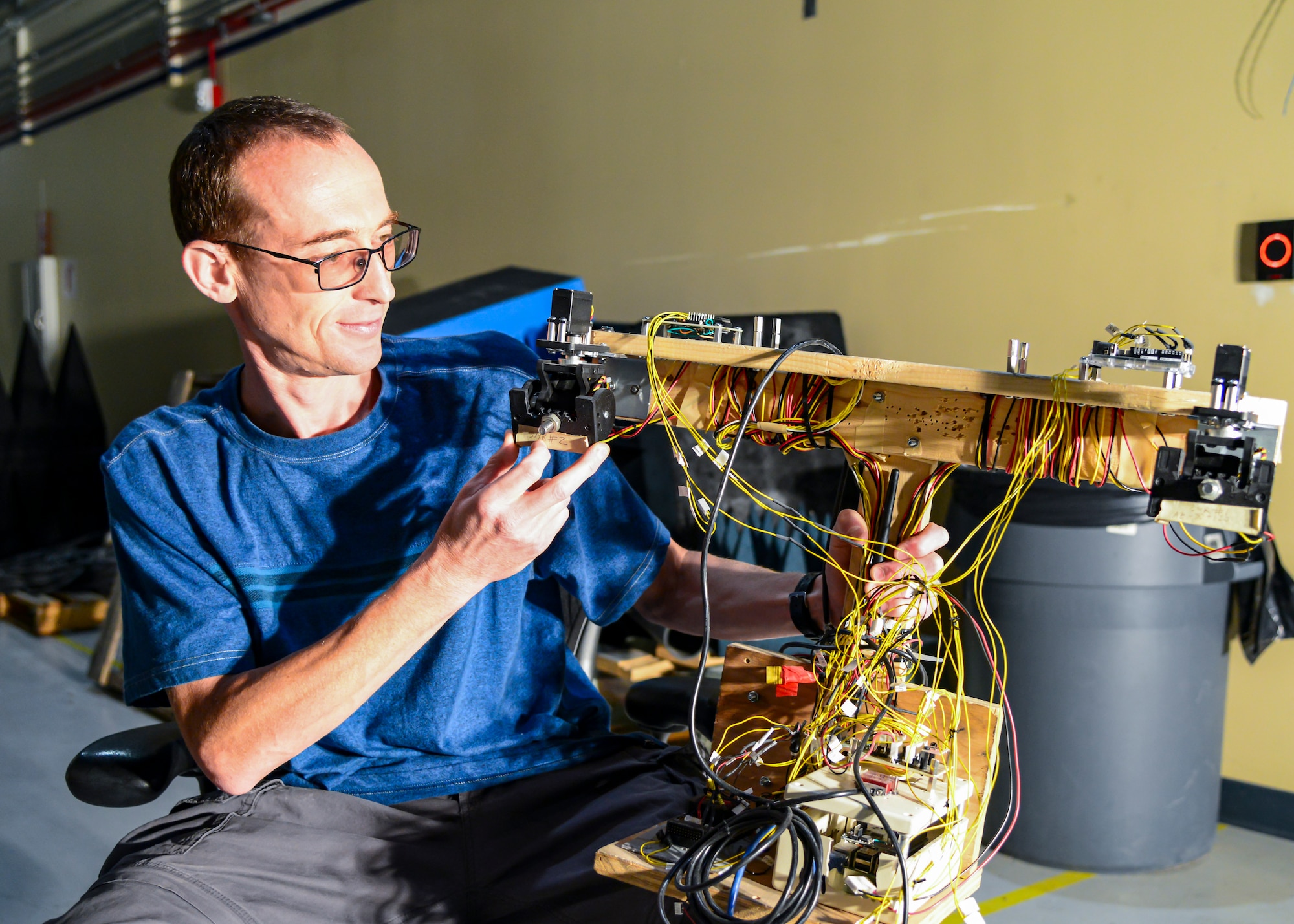 Aleksandr Yarovinskiy explains the workings of a non-flying drone mock-up he built to develop and verify the accuracy of the laser positioning system he designed so a drone would be able to safely and accurately navigate inside the main chamber of the Benefield Anechoic Facility. Yarovinskiy has secured funding from SparkED, the 412th Test Wing’s innovation team, to design, build, test and deliver a drone that has the potential to expand and enhance the BAF’s data-capture capabilities. (Air Force photo by Gary Hatch)