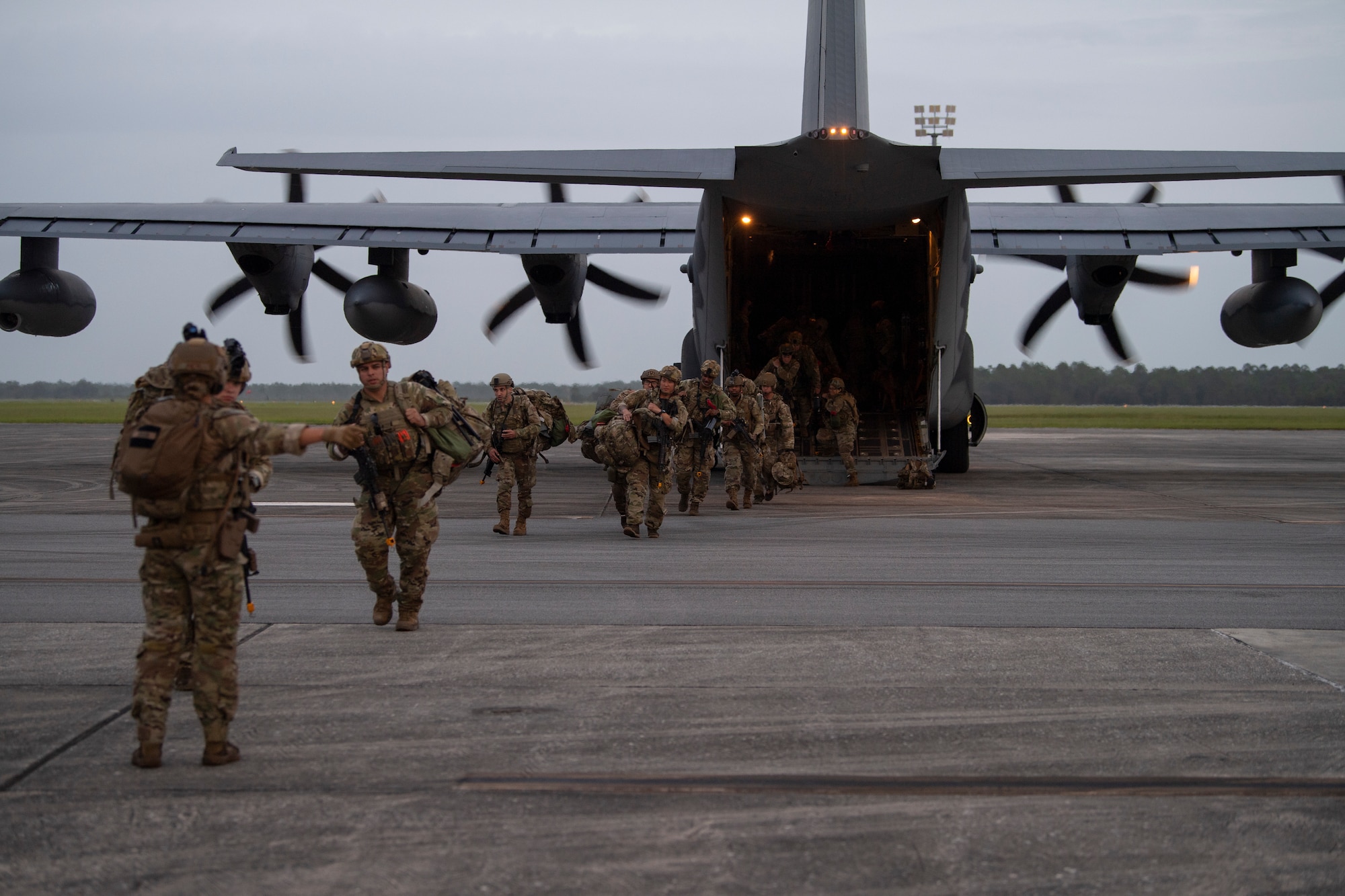 A photo of multiple Airmen running out of the ramp of an HC-130J Combat King II.
