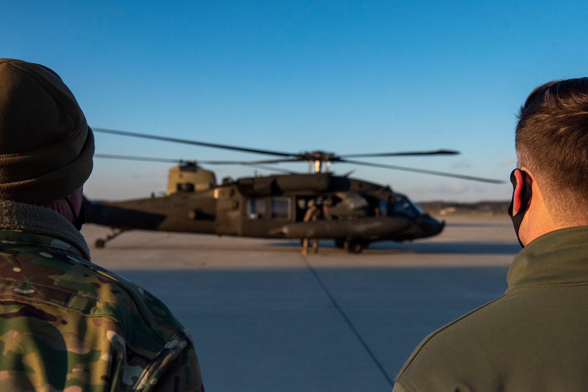 Col. Joshua Wood, 51st Fighter Wing commander, right, and Chief Master Sgt. Justin Apticar, 51st Fighter Wing command chief, left, watch Lloyd J. Austin III, United States Secretary of Defense, leave the base by helicopter