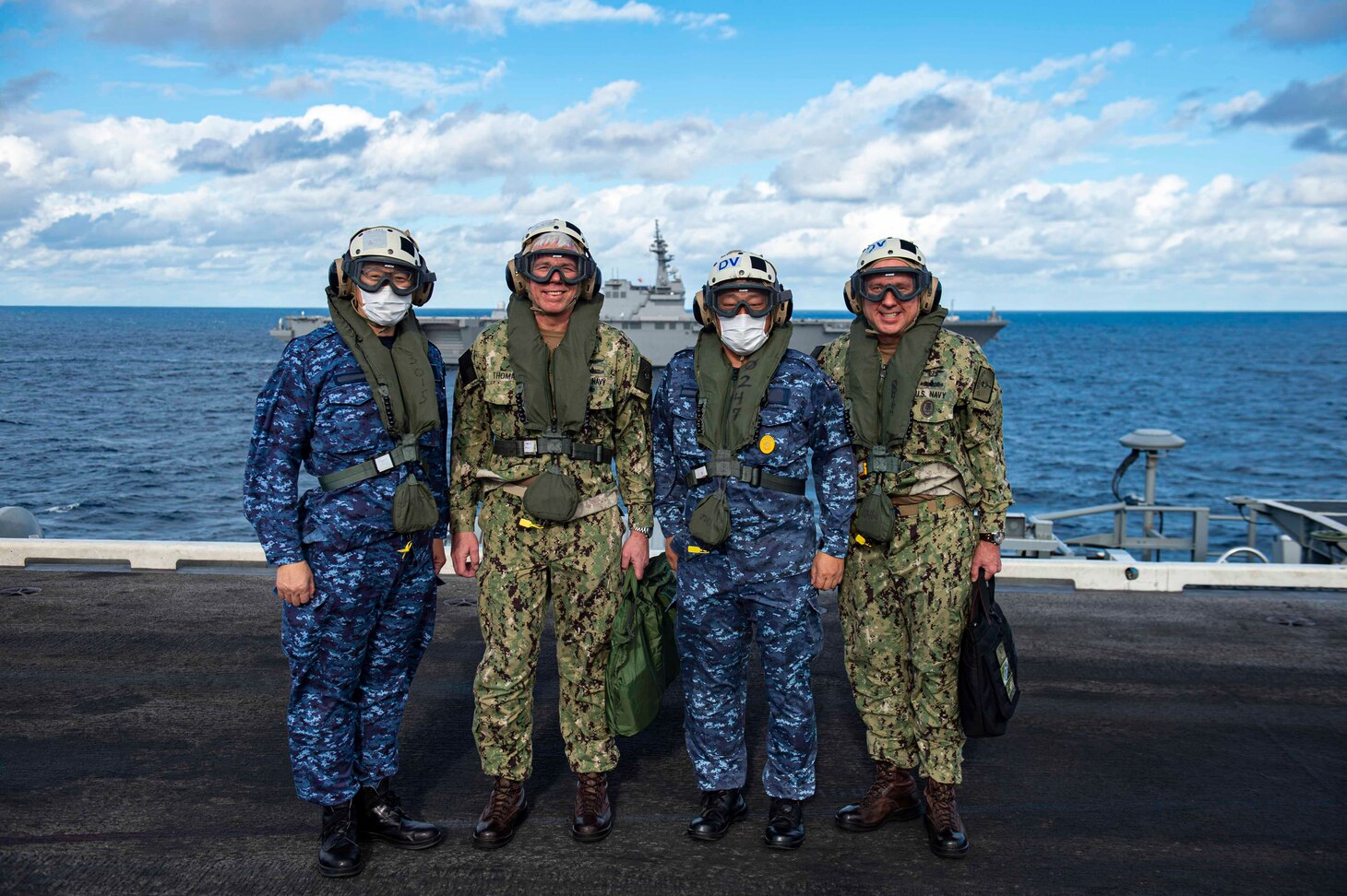 211130-N-IW069-1231 PHILIPPINE SEA (Nov. 30, 2021) From left to right Vice Adm. Hideki Yuasa, commander, Japan Maritime Self-Defense Force (JMSDF), Vice Adm. Karl Thomas, commander, U.S. 7th Fleet, Japan Maritime Self Defense Force Fleet Master Chief Yoshihiro Aoyama, Self Defense Force, U.S. 7th Fleet Command Master Chief Jason Haka, pose for a photo on the flight deck of Nimitz-class aircraft carrier USS Carl Vinson (CVN 70), during Annual Exercise (ANNUALEX) 2021, Nov. 30, 2021. ANNUALEX 2021 is a multilateral exercise conducted by naval elements of the Royal Australian, Royal Canadian, German, JMSDF and U.S. navies to demonstrate naval interoperability and a joint commitment to a free, open and inclusive Indo-Pacific. (U.S. Navy photo by Mass Communication Specialist 3rd Class Isaiah M. Williams) (This photo has been altered for security purposes by blurring out name tapes.)