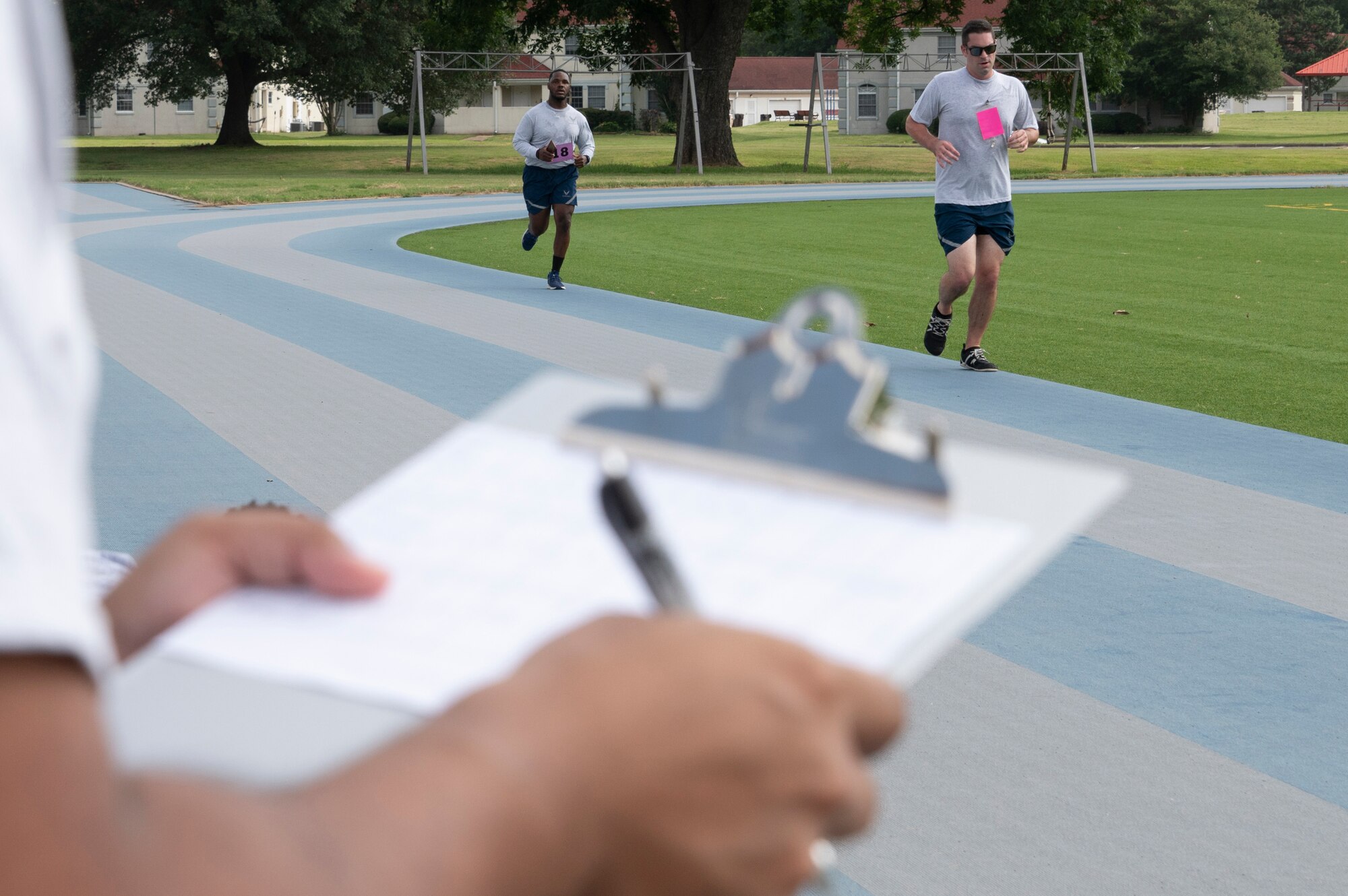 Airmen run around a track
