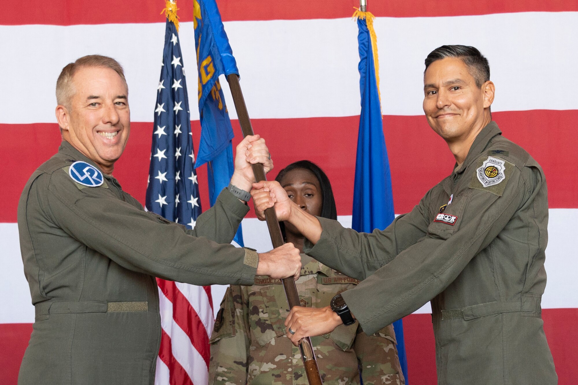 Two Airman hold a unit guidon