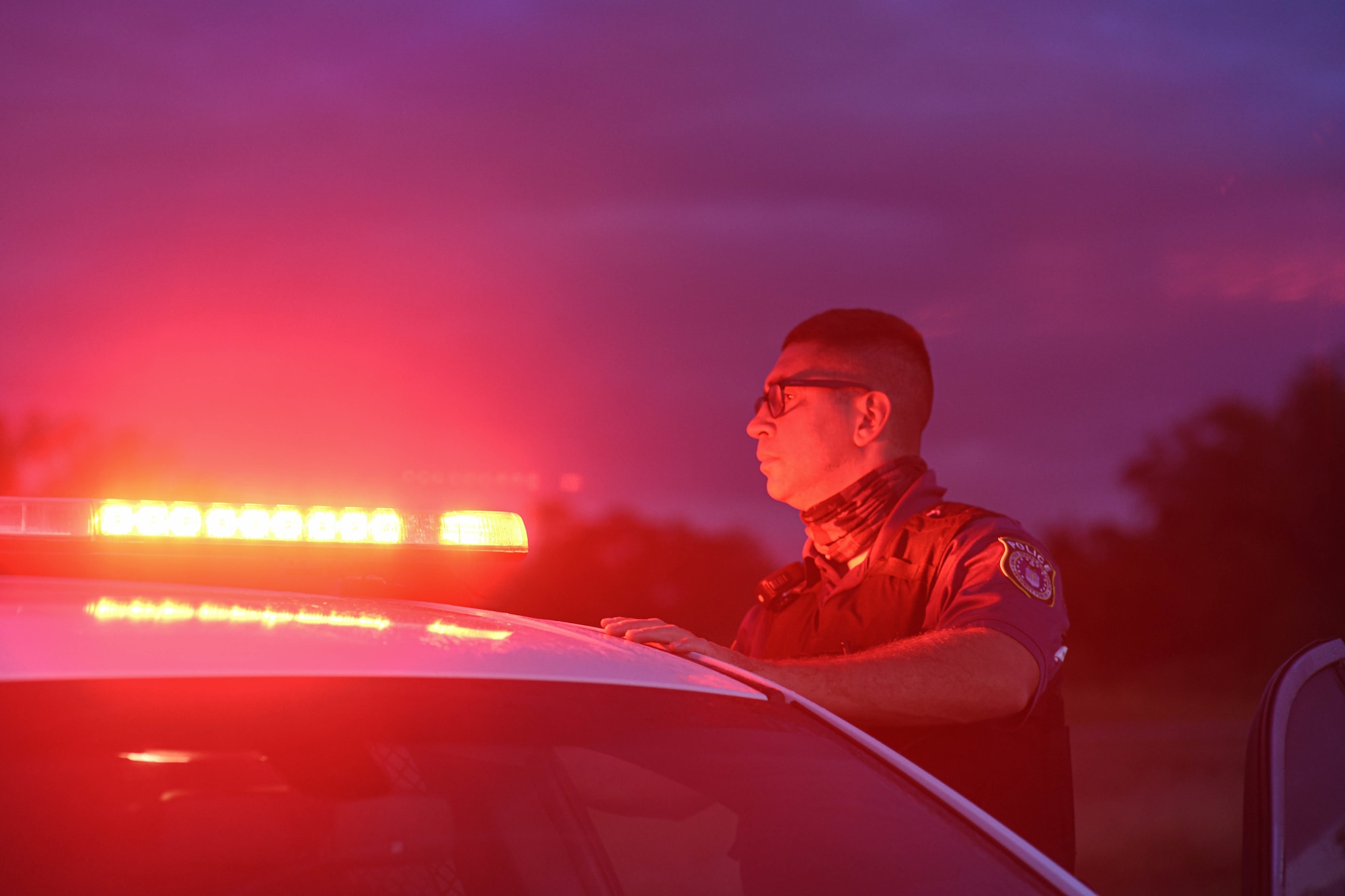 A patrol car's lights flash red as Archer Seavolt, 325th Security Forces Squadron patrolman, does a routine inspection