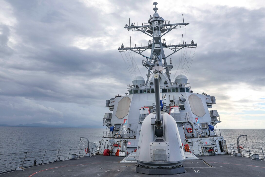 A military ship moves through the water.