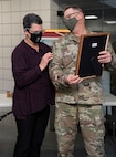 Col. Randall Gates presents his wife, Lou, with a certificate of appreciation during his retirement ceremony at Camp Johnson, Vermont, on Nov. 30, 2021. Gates, the Vermont National Guard's director of military support, served as an enlisted Soldier for 11 years and a commissioned officer for 27. (U.S. Army National Guard photo by Don Branum)