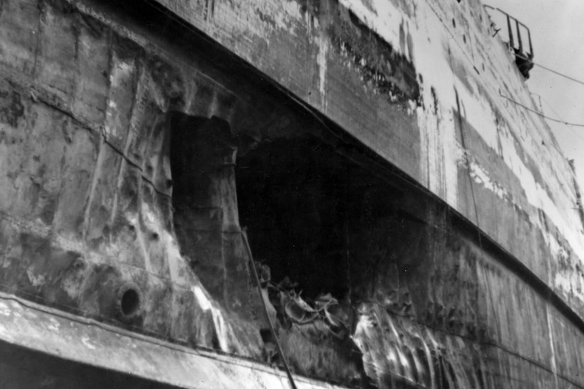 A massive hole is seen in the side of a battleship.