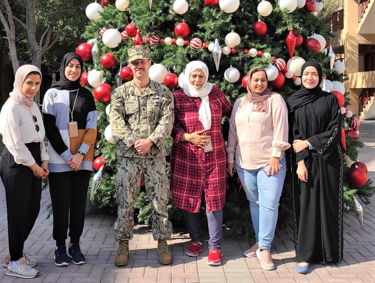 BAHRAIN (Dec. 1, 2021)  Cmdr. Adam Kushner, Public Works Officer, Public Works Department, Naval Support Activity, Bahrain poses with five of the six PWD Bahrain female employees in celebration of Bahraini Women’s Day, Dec. 1.  This is the 20th anniversary of the celebration that commemorates the achievements and creative contribution made by women to the development and progress of Bahrain.  Joining Kushner in the photo, from left to right, are Ms. Mariam Ghuloom, Engineering Technician, Facilities Support Contracts Branch; Ms. Hawra Abu-Idrees, Management and Program Assistant, Environmental Division; Cmdr. Kushner; Ms. Layla Turabi, Chemical Engineer, Potable Water Manager, Environmental Division and Ms. Maryam Haider, Host Nation Community Planner.  Unfortunately, Ms. Nada Ghazwan, Procurement Technician, Contracting Department was not available to appear in the photo.  Naval Facilities Engineering Systems Command, Europe, Africa, Central, Public Works Department, Naval Support Activity Bahrain enables mission support to personnel and operational assets within the Navy Central Command/5th FLEET Area of Responsibility through deliberate planning and execution of installation facility support requirements.  (U.S. Navy photo by Construction Electrician 2nd Class Quenniemay Galarpe/Released)