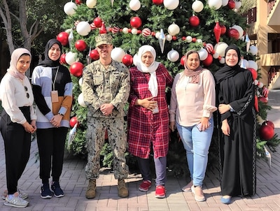 BAHRAIN (Dec. 1, 2021)  Cmdr. Adam Kushner, Public Works Officer, Public Works Department, Naval Support Activity, Bahrain poses with five of the six PWD Bahrain female employees in celebration of Bahraini Women’s Day, Dec. 1.  This is the 20th anniversary of the celebration that commemorates the achievements and creative contribution made by women to the development and progress of Bahrain.  Joining Kushner in the photo, from left to right, are Ms. Mariam Ghuloom, Engineering Technician, Facilities Support Contracts Branch; Ms. Hawra Abu-Idrees, Management and Program Assistant, Environmental Division; Cmdr. Kushner; Ms. Layla Turabi, Chemical Engineer, Potable Water Manager, Environmental Division and Ms. Maryam Haider, Host Nation Community Planner.  Unfortunately, Ms. Nada Ghazwan, Procurement Technician, Contracting Department was not available to appear in the photo.  Naval Facilities Engineering Systems Command, Europe, Africa, Central, Public Works Department, Naval Support Activity Bahrain enables mission support to personnel and operational assets within the Navy Central Command/5th FLEET Area of Responsibility through deliberate planning and execution of installation facility support requirements.  (U.S. Navy photo by Construction Electrician 2nd Class Quenniemay Galarpe/Released)