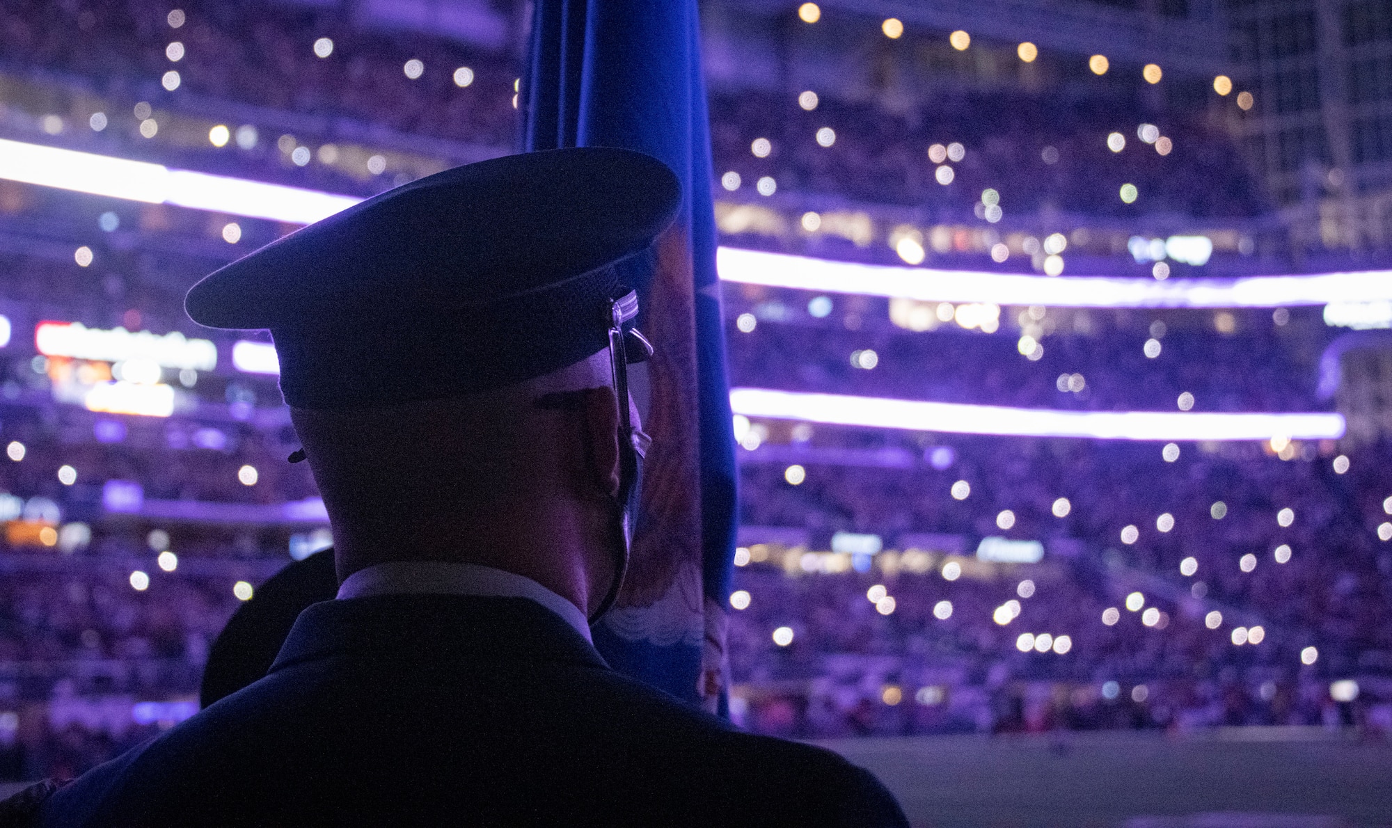 One honor guardsman stands in front of an empty stadium