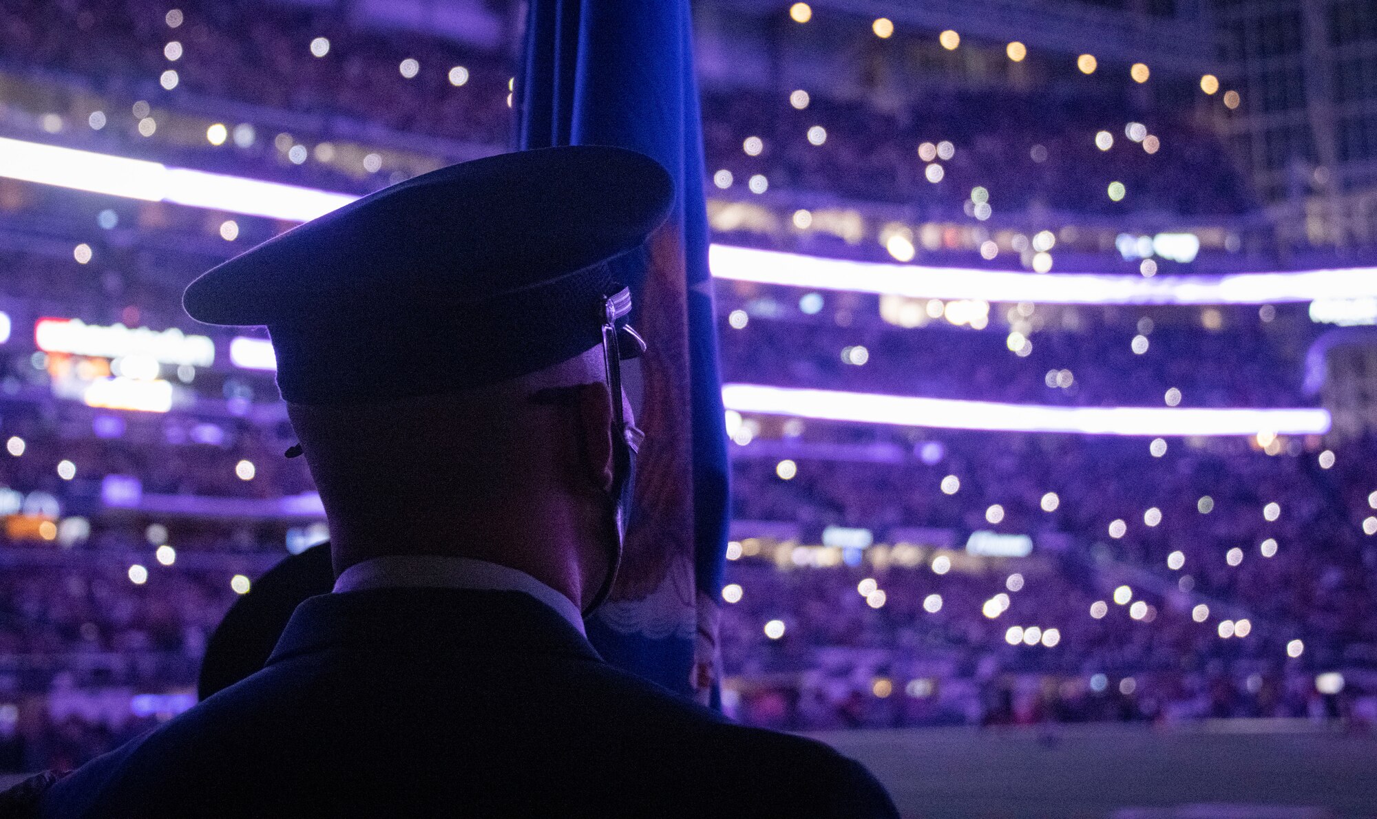 One honor guardsman stands in front of an empty stadium