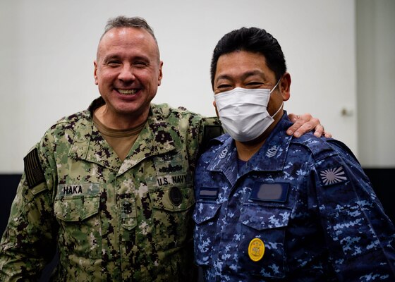 211130-N-SS900-1109 PHILIPPINE SEA (Nov. 30, 2021) U.S. 7th Fleet Command Master Chief Chief Jason Haka, left, and Japan Maritime Self-Defense Force (JMSDF) Fleet Master Chief Yoshihiro Aoyama, fleet master chief of Self Defense Force, pose for a photo in the hangar bay aboard Nimitz-class aircraft carrier USS Carl Vinson (CVN 70) during Annual Exercise (ANNUALEX) 2021, Nov. 30, 2021. ANNUALEX 2021 is a multilateral exercise conducted by naval elements of the Royal Australian, Royal Canadian, German, JMSDF and U.S. navies to demonstrate naval interoperability and a joint commitment to a free, open and inclusive Indo-Pacific. (U.S. Navy photo by Mass Communication Specialist 2nd Class Aaron T. Smith) (This photo has been altered for security purposes by blurring out name tapes.)