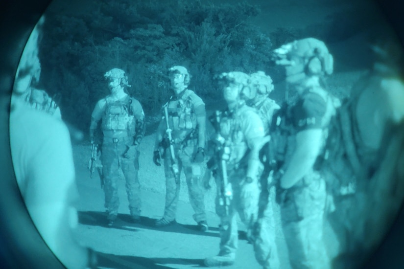 Soldiers are visible through a night-vision optic.
