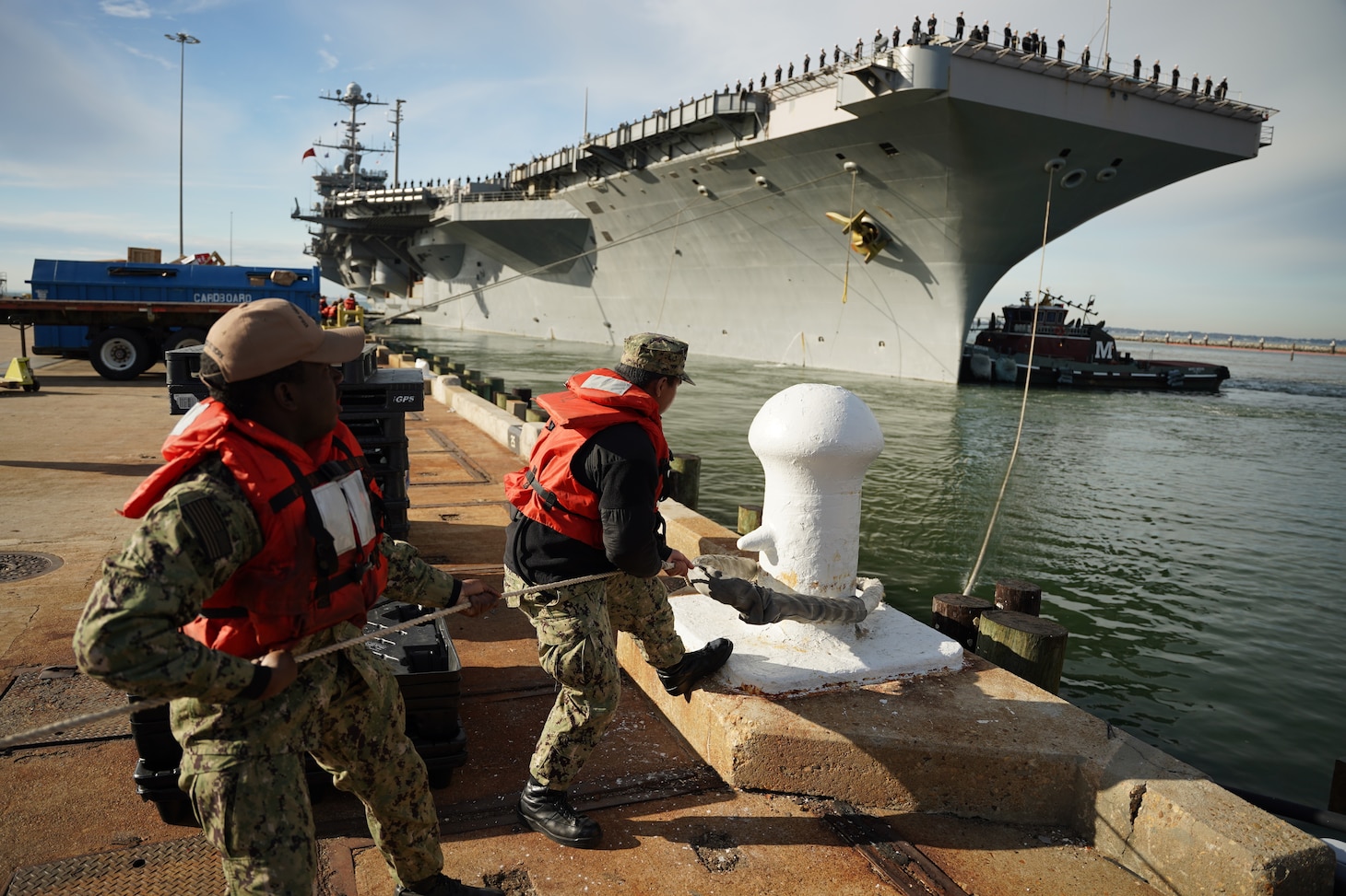 Sailors man the rails of USS Harry S. Truman (CVN 75) as the ship departs Naval Station Norfolk for deployment.