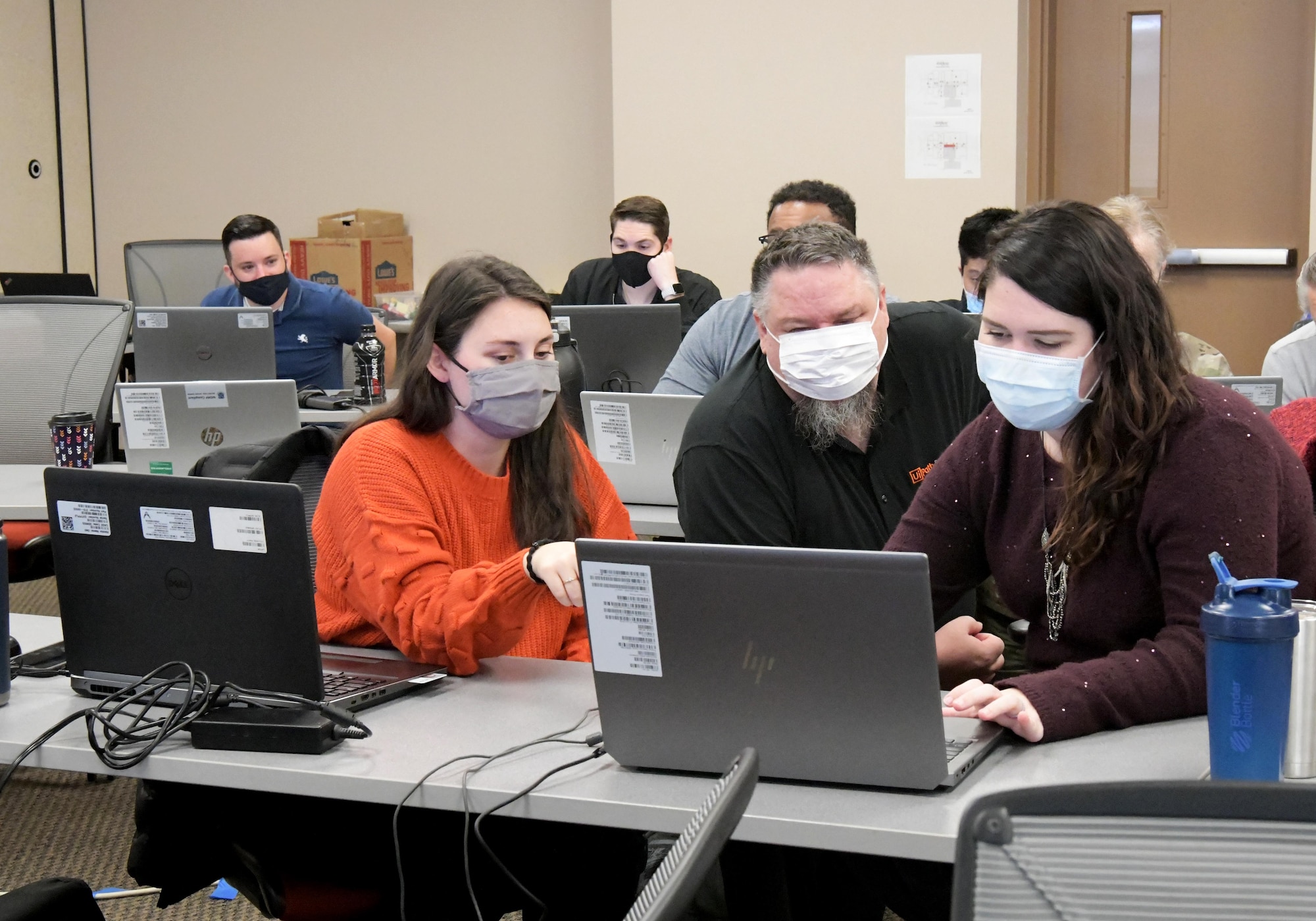 three people looking at computer