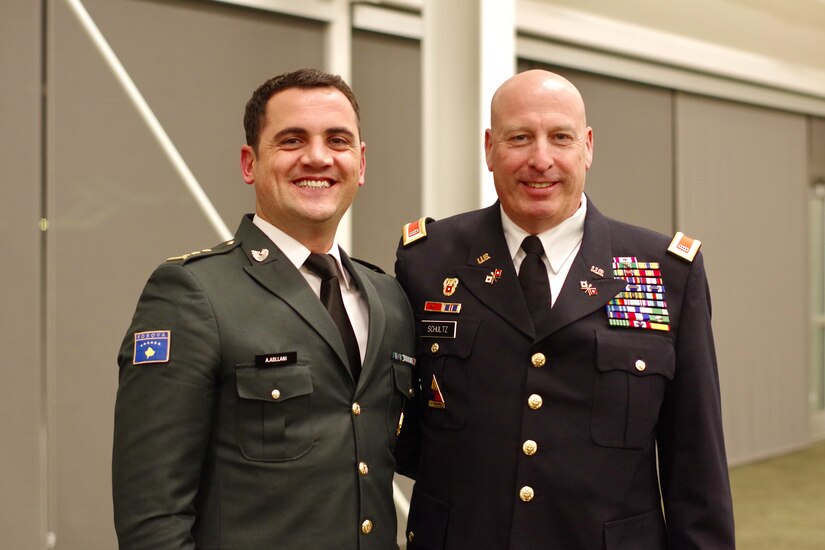 Capt. Albert Aslani of the Kosovo Security Force and retired Chief Warrant Officer 5 Matthew Schultz of the Iowa National Guard share a moment at a dinner at the Des Moines Area Community College in Ankeny, Iowa, Nov. 8, 2021. Iowa and Kosovo commemorated their 10-year formal partnership under the State Partnership Program.