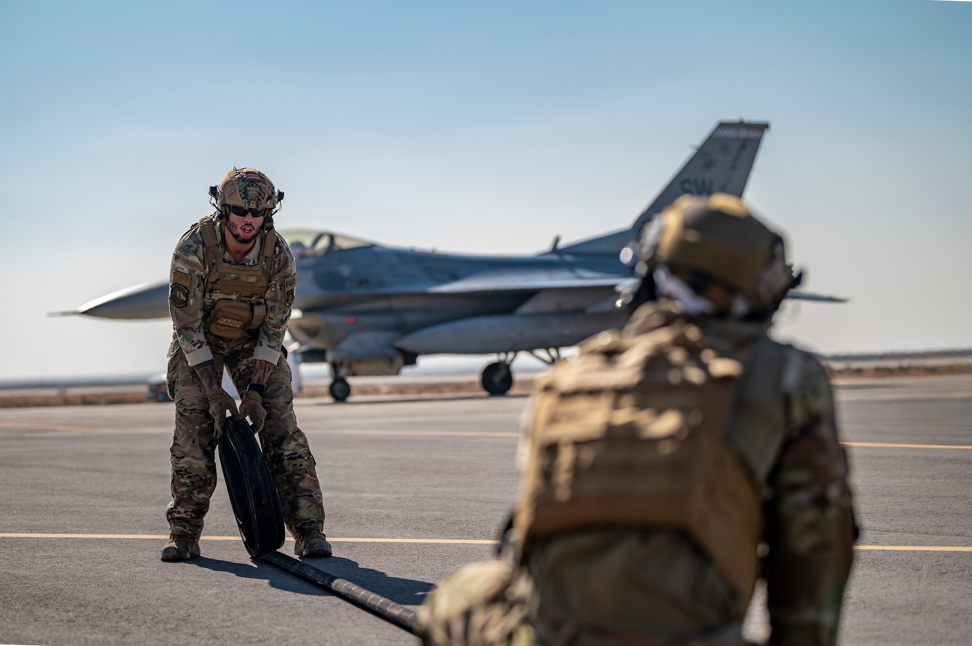 U.S. Airmen from the 26th Expeditionary Rescue Squadron participate in a Forward Area Refueling Point (FARP) exercise for two F-16C Fighting Falcons Nov. 26, 2021, at an undisclosed location somewhere in Southwest Asia.