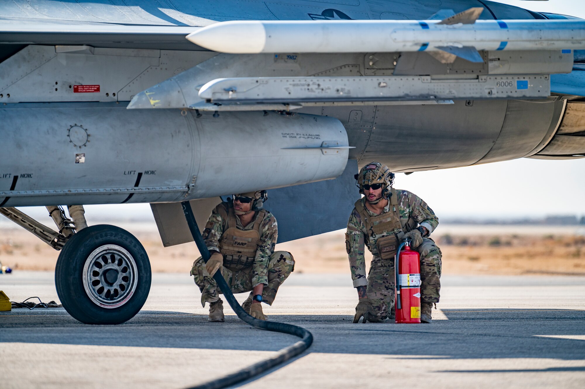 U.S. Airmen from the 26th Expeditionary Rescue Squadron participate in a Forward Area Refueling Point (FARP) exercise for two F-16C Fighting Falcons Nov. 26, 2021, at an undisclosed location somewhere in Southwest Asia.