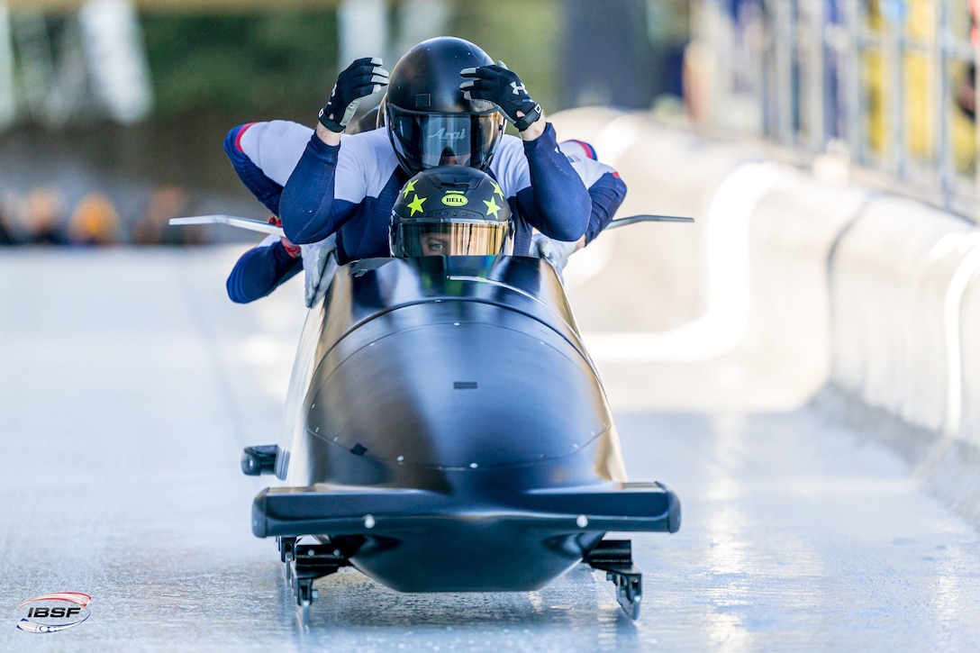 Athletes slide in a bobsled