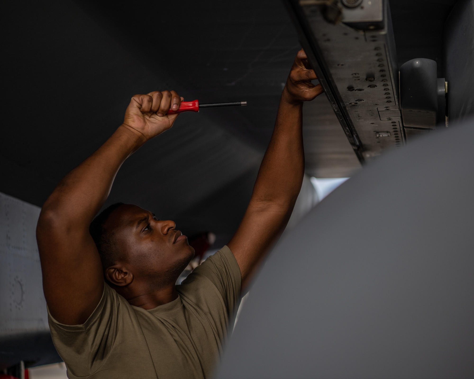 An Airman prepares a missile rack for munitions loading