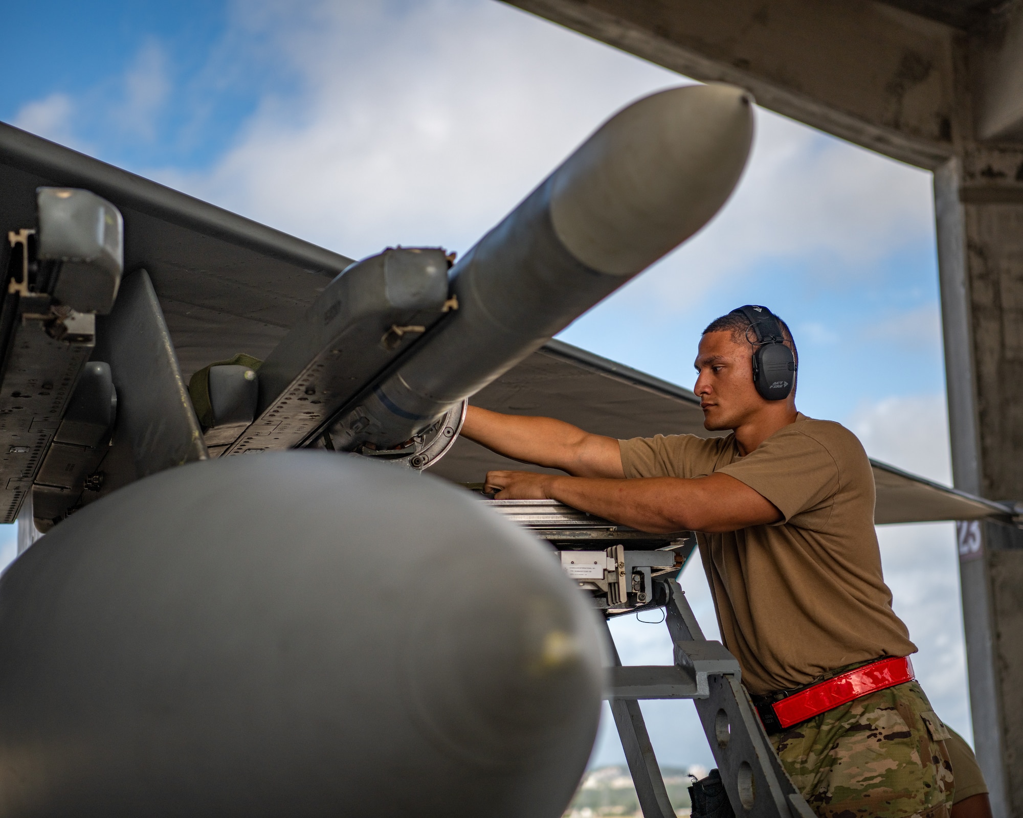 An Airman loads a missile on an fighter jet