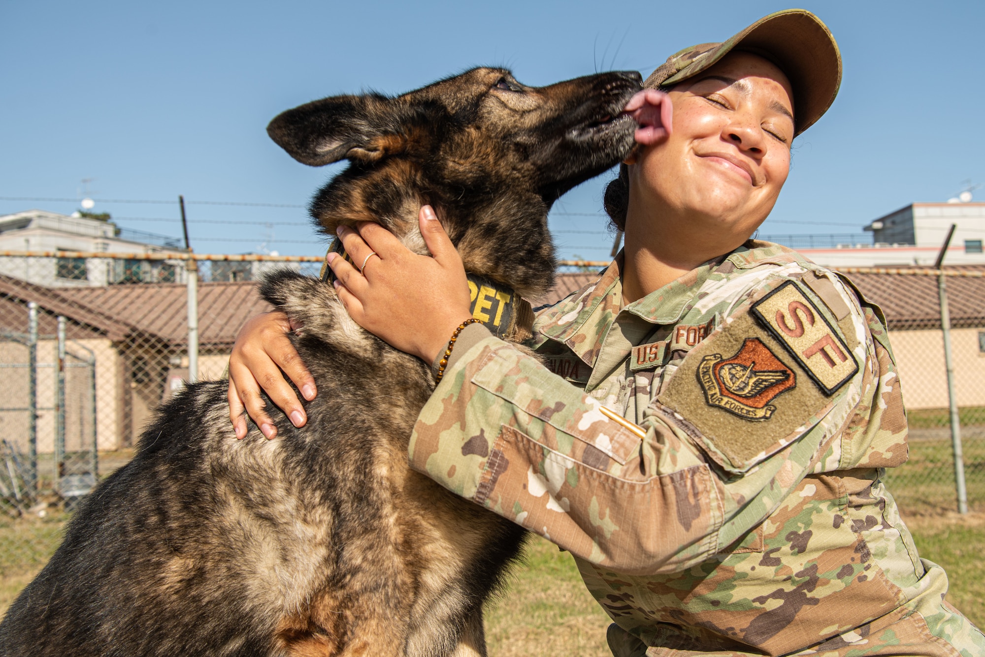 Senior Airman Jenna Canada, 51st Security Forces Squadron military working dog handler, embraces Akim, her MWD, at Osan Air Base, Republic of Korea, Nov. 17, 2021.