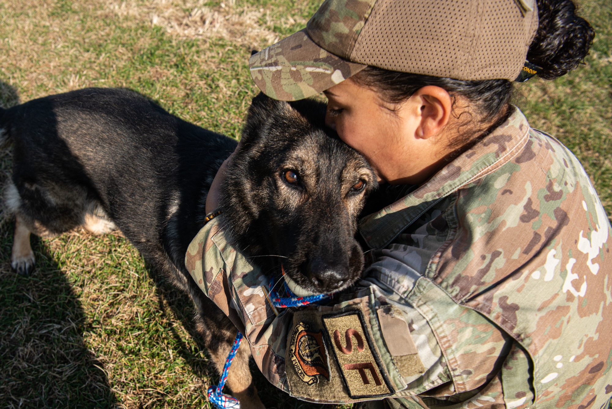 Senior Airman Jenna Canada, 51st Security Forces Squadron military working dog handler, embraces Akim, her MWD, at Osan Air Base, Republic of Korea, Nov. 17, 2021.