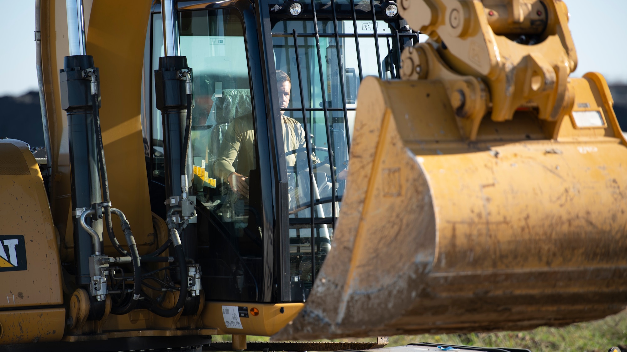 A construction worker drives a front loading scoop truck