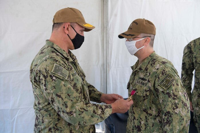 Rear Adm. Scott Robertson, commander, Carrier Strike Group Two, presents Capt. Scott Jones with the Legion of Merit at the Destroyer Squadron (DESRON) 22 change of command ceremony on board the Arleigh Burke-class guided-missile destroyer USS Mitscher (DDG 57). DESRON 22 consists of guided-missile destroyers, including Mitscher, USS Laboon (DDG 58), USS Ramage (DDG 61), and USS Mahan (DDG 72). Established in March 1943, DESRON 22 is one of the oldest destroyer squadrons in the U.S. Navy. (U.S. Navy photo by Mass Communication Specialist 1st Class Jacob Milham/Released)