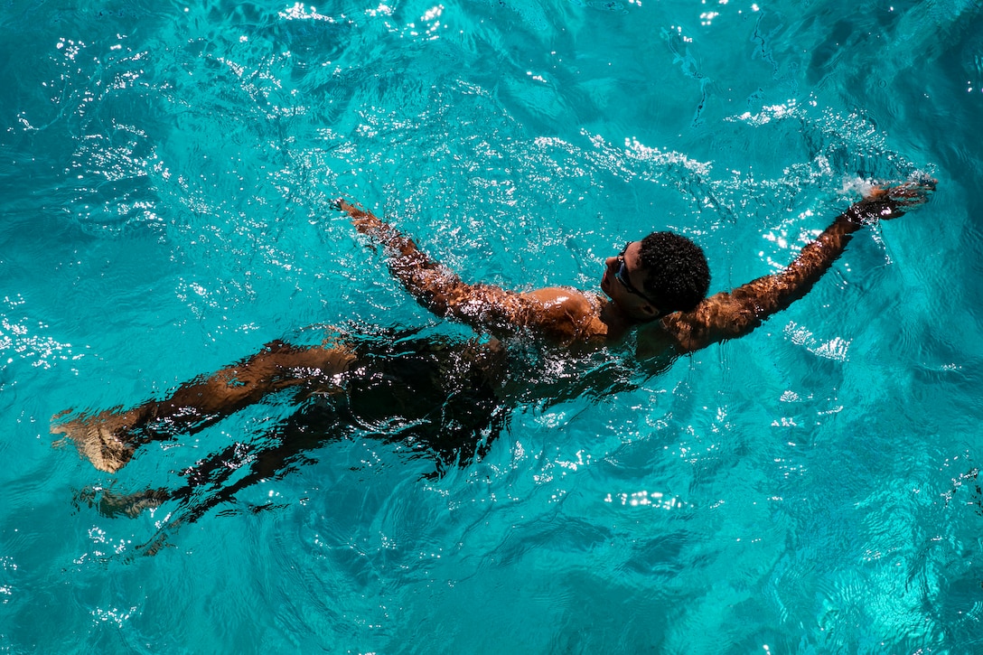 A Marine swims in the water.