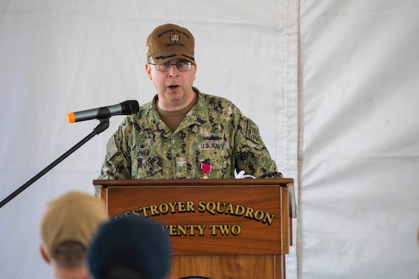 Capt. Scott Jones, the outgoing commodore, Destroyer Squadron (DESRON) 22, speaks at the DESRON 22 change of command ceremony on board the Arleigh Burke-class guided-missile destroyer USS Mitscher (DDG 57). DESRON 22 consists of guided-missile destroyers, including Mitscher, USS Laboon (DDG 58), USS Ramage (DDG 61), and USS Mahan (DDG 72). Established in March 1943, DESRON 22 is one of the oldest destroyer squadrons in the U.S. Navy. (U.S. Navy photo by Mass Communication Specialist 1st Class Jacob Milham/Released)
