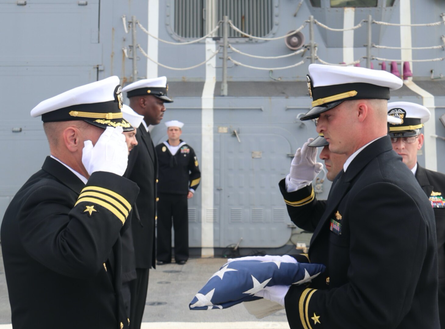 Cmdr. Jason Horning prepares to receive the American flag from Lt. j. g. Alexander Armstrong during a Burial at Sea ceremony, Nov. 14. (Photo by Ens. Alexander Simon)
