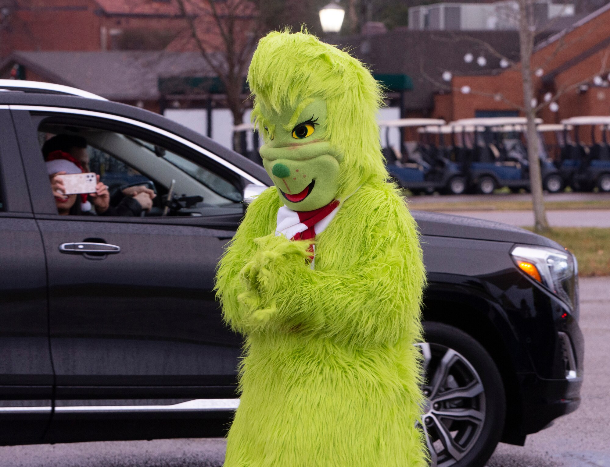 The Grinch keeps an eye out for holiday cheer during the 2021 Tree Lighting drive-thru event hosted by the 88th Force Support Squadron at Wright-Patterson Air Force Base, Ohio, Dec. 1, 2021. Families were able to go through the drive-thru, get goody bags and hot chocolate from Santa’s elves, and then park to watch the lighting of the base’s Christmas tree over Facebook Live. (U.S. Air Force photo by Jaima Fogg)