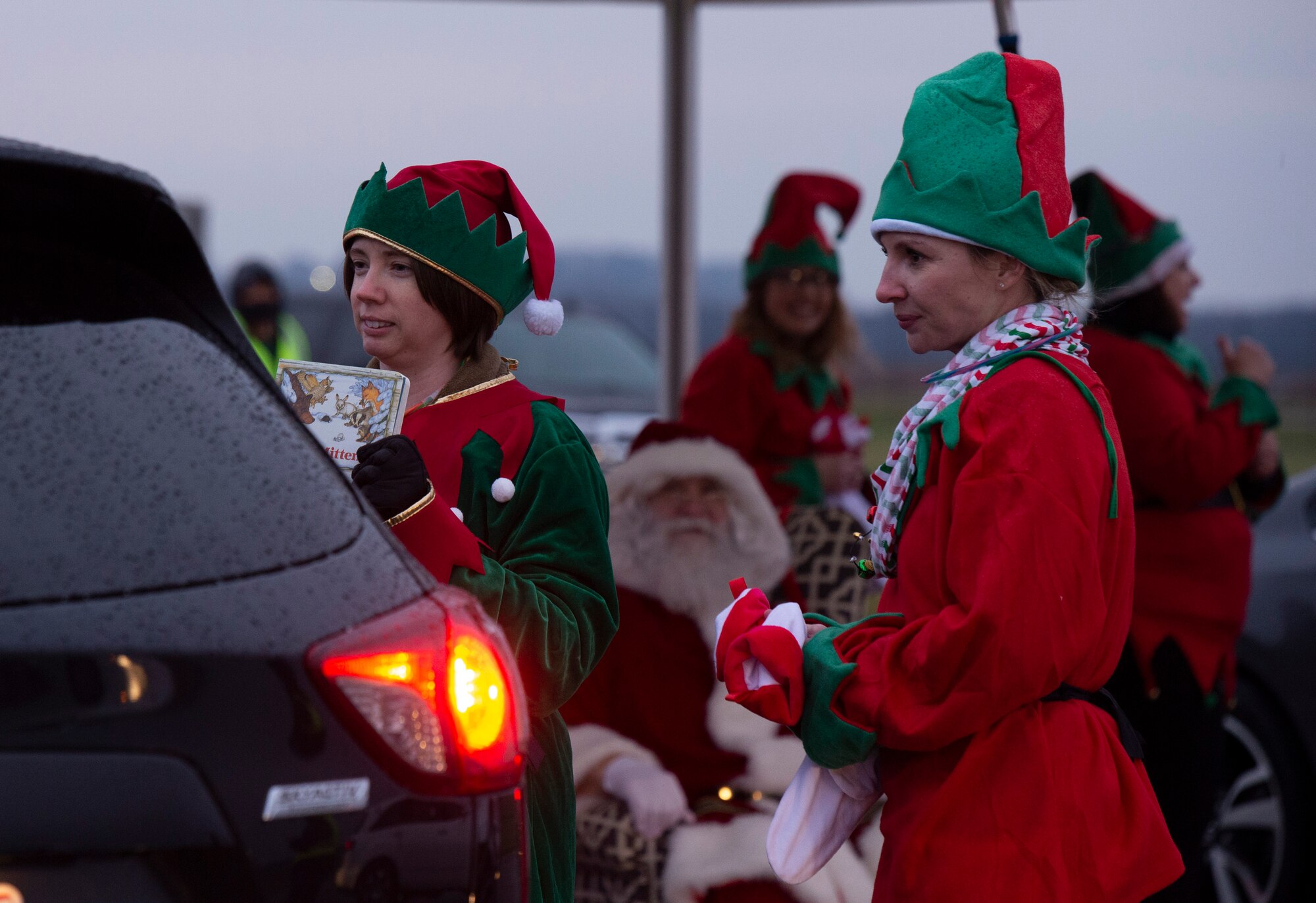 Some of Santa’s elves pass out goodie bags during 2021 Tree Lighting drive-thru event hosted by the 88th Force Support Squadron at Wright-Patterson Air Force Base, Ohio, Dec. 1, 2021. Families were able to go through the drive-thru, get goody bags and hot chocolate from Santa’s elves, and then park to watch the lighting of the base’s Christmas tree over Facebook Live. (U.S. Air Force photo by Jaima Fogg)