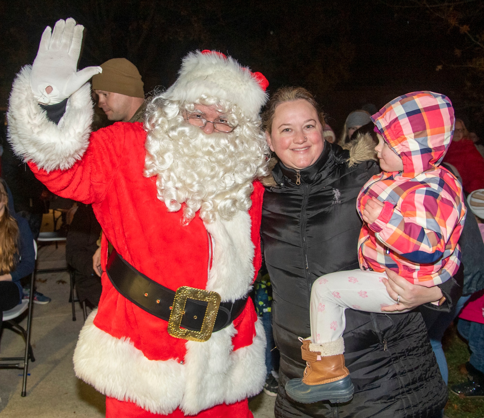 Kayla Hansen, middle, and her daughter, Lila, pose for a photo with Santa Claus during the annual Holiday Parade and Tree Lighting Ceremony at Dover Air Force Base, Delaware, Dec. 1, 2021. The annual ceremony marks the start of the holiday season at Dover AFB. (U.S. Air Force photo by Tech. Sgt. Nicole Leidholm)