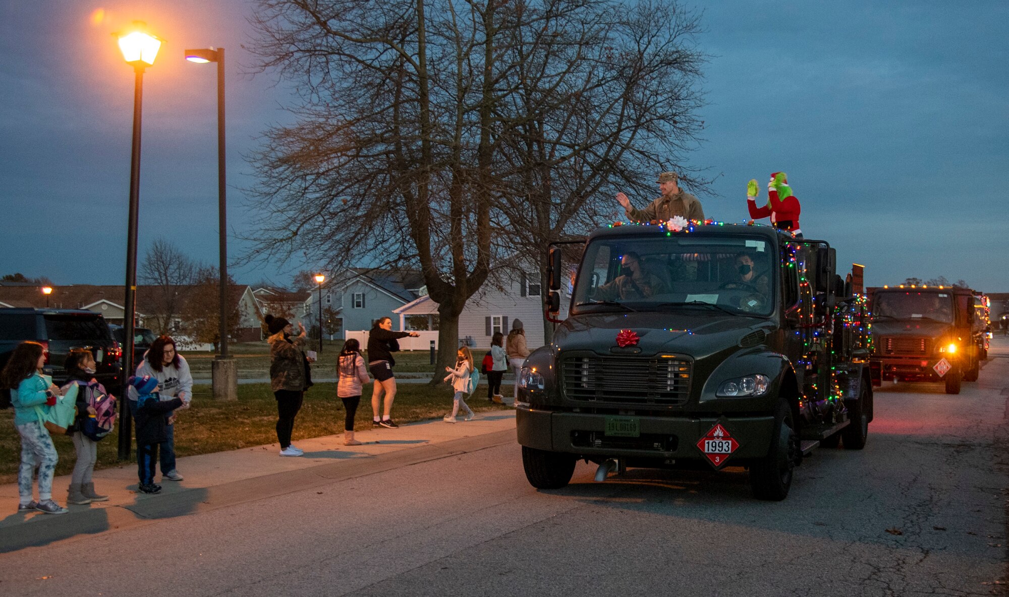 Col. Matt Husemann (left on truck), 436th Airlift Wing commander, and the Grinch, wave to members of Team Dover during the annual Holiday Parade and Tree Lighting Ceremony at Dover Air Force Base, Delaware, Dec. 1, 2021. Airmen from the 436th Security Forces, 436th Logistics Readiness, 436th Force Support and 436th Civil Engineer Squadrons drove vehicles around base housing to bring holiday cheer. (U.S. Air Force photo by Tech. Sgt. Nicole Leidholm)