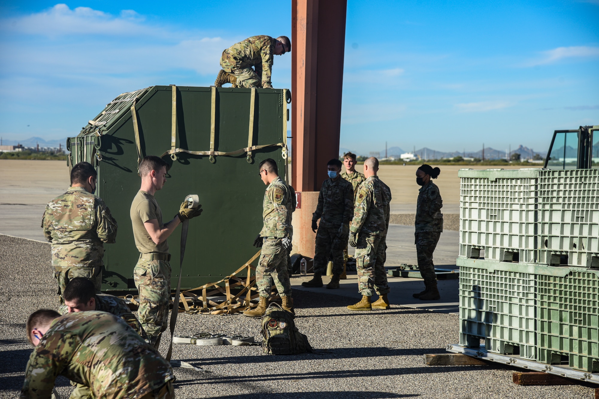 Pictured above is a group of Airmen removing the cargo net from a container and folding the netting.