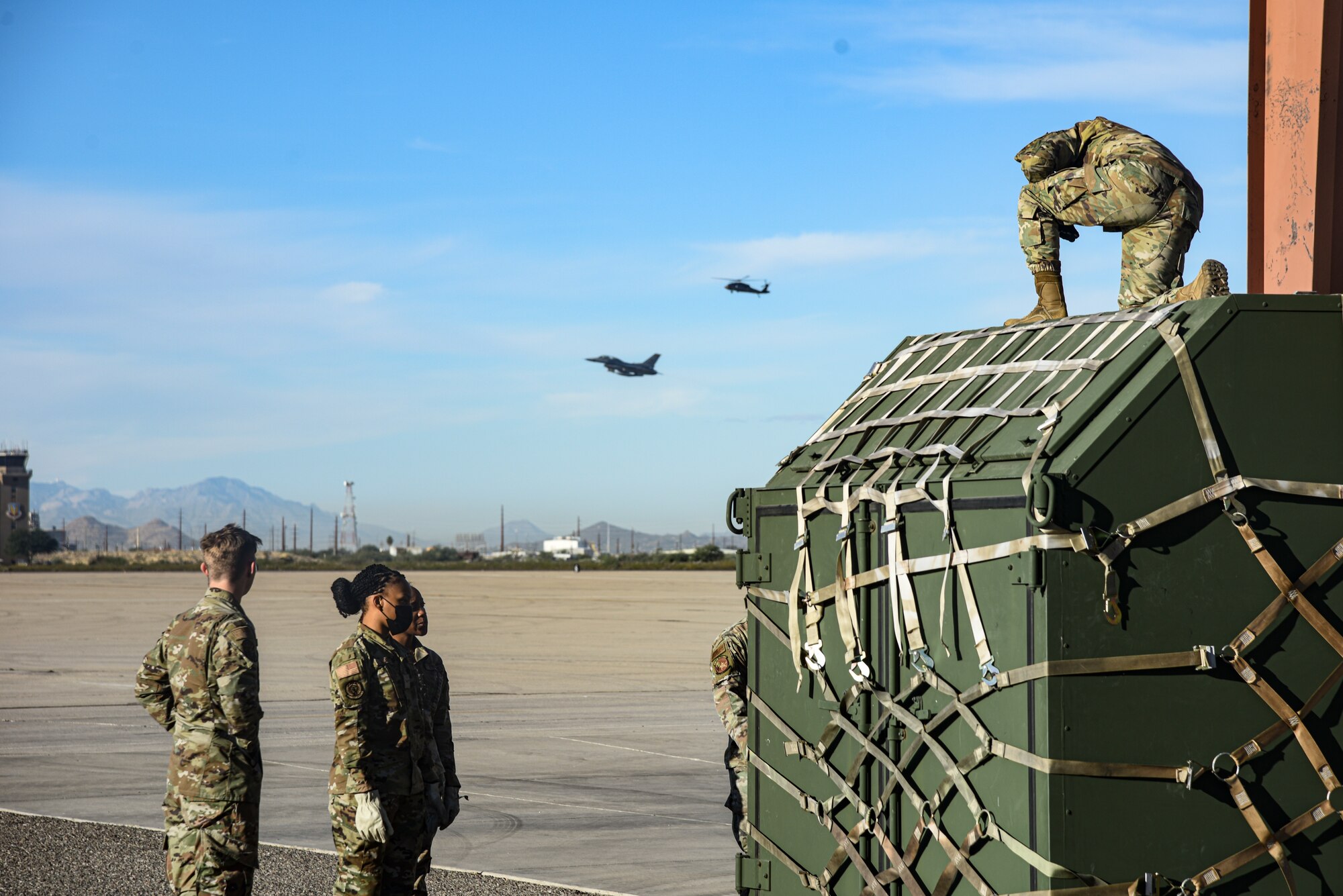 Pictured above is a group of Airmen standing around a container that has been strapped to a pallet.