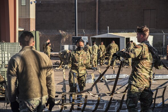 Pictured above is a group of Airmen pulling apart a large cargo net.