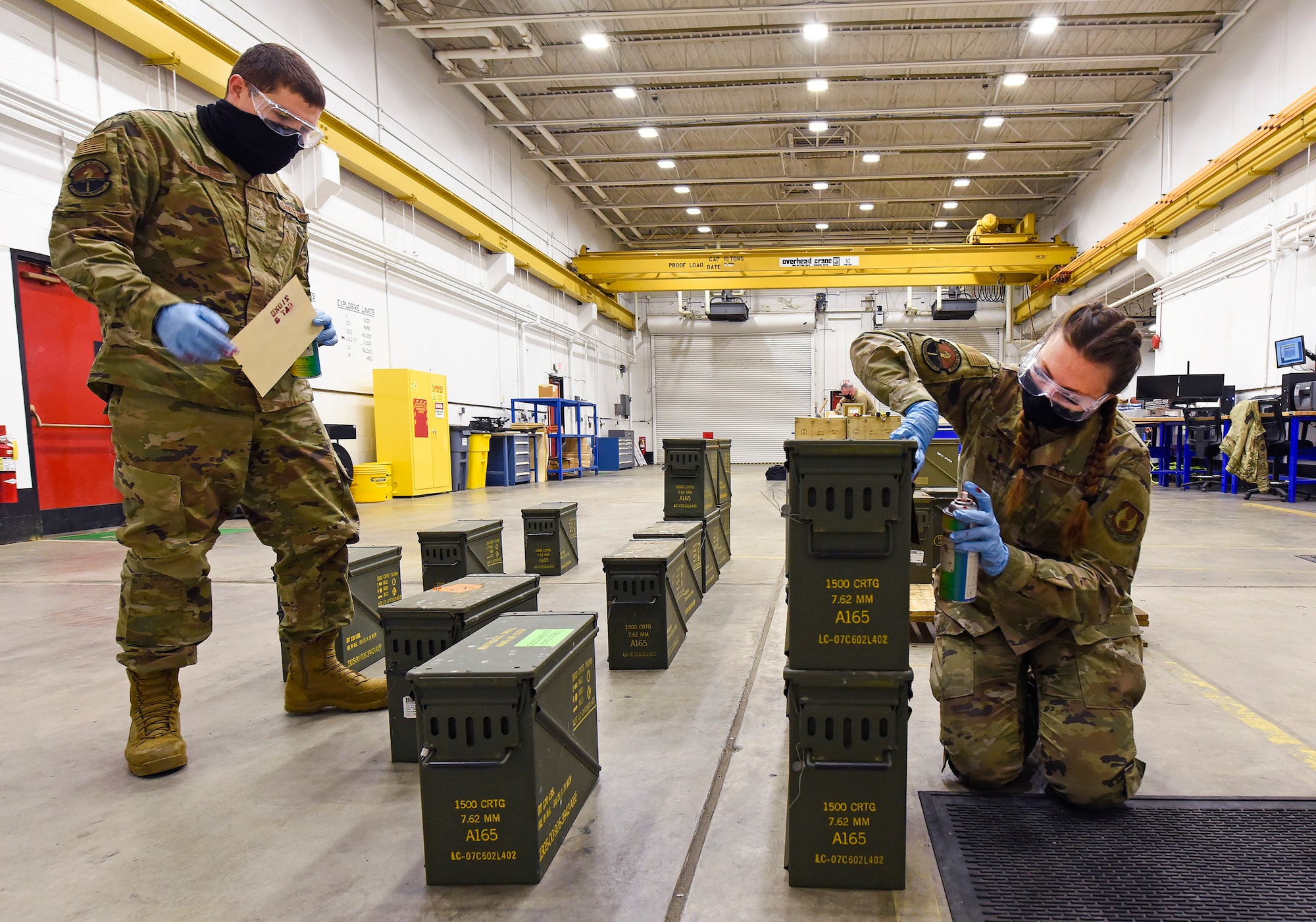 Senior Airman Ryan Klingbeil, an 88th Operations Support Squadron storage crew chief, and Staff Sgt. Jacklyn Hill, an 88 OSS munitions inspector, stencil ammo boxes they are packing March 3, 2021, at Wright-Patterson Air Force Base, Ohio. The Munitions Flight ships, stores, inspects, receipts and accounts for all ammo assets on Wright-Patt. (U.S. Air Force photo by Ty Greenlees)