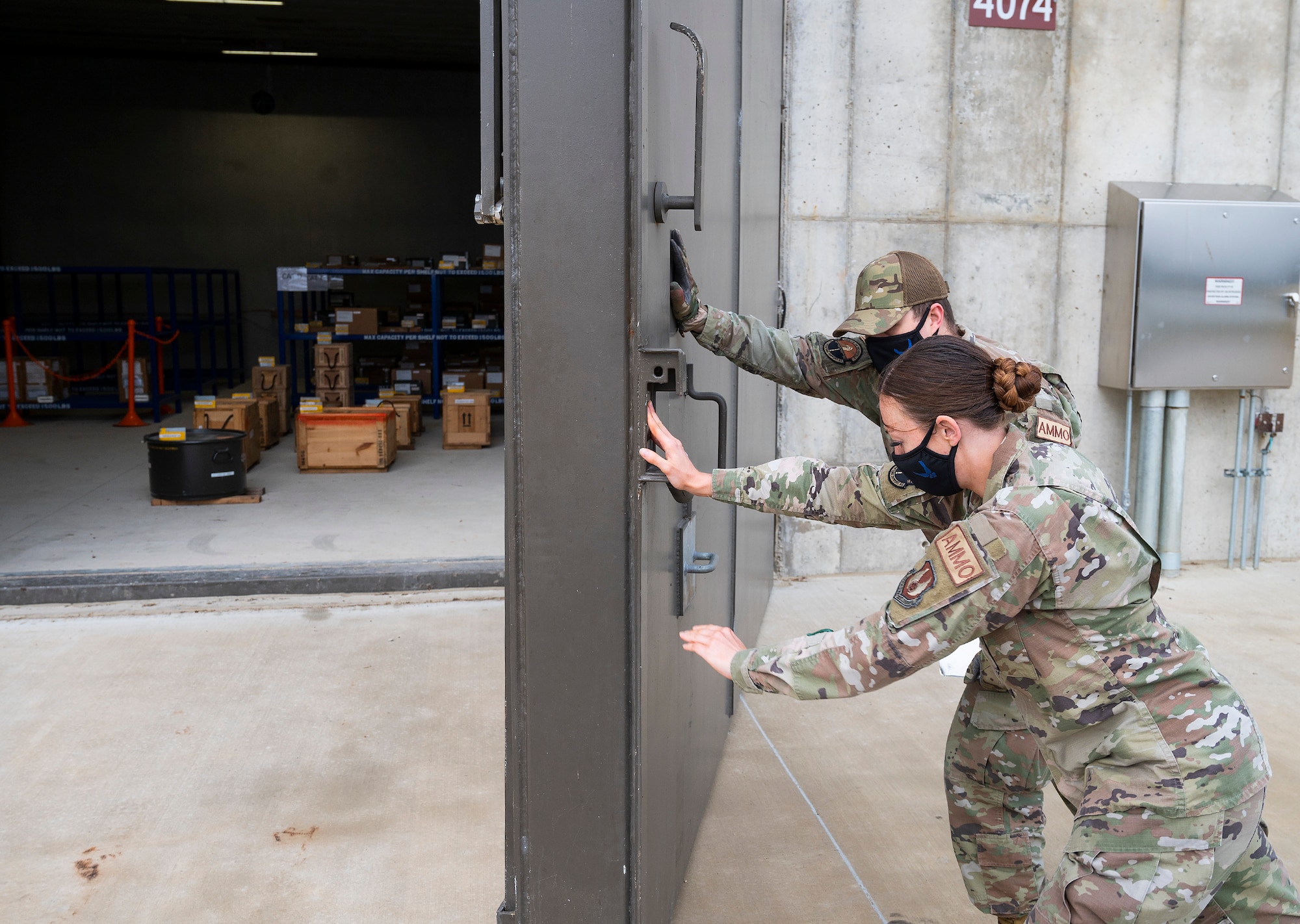 Staff Sgt. Jacklyn Hill and Senior Airman Ryan Klingbeil, 88th Operations Support Squadron Munitions Flight inspectors, close a large, armored door to one of the new explosives-storage igloos Nov. 17, 2021, at Wright-Patterson Air Force Base, Ohio. The $6.5 million construction project greatly increased the squadron’s munitions capabilities while reducing its footprint. (U.S. Air Force photo by R.J. Oriez)