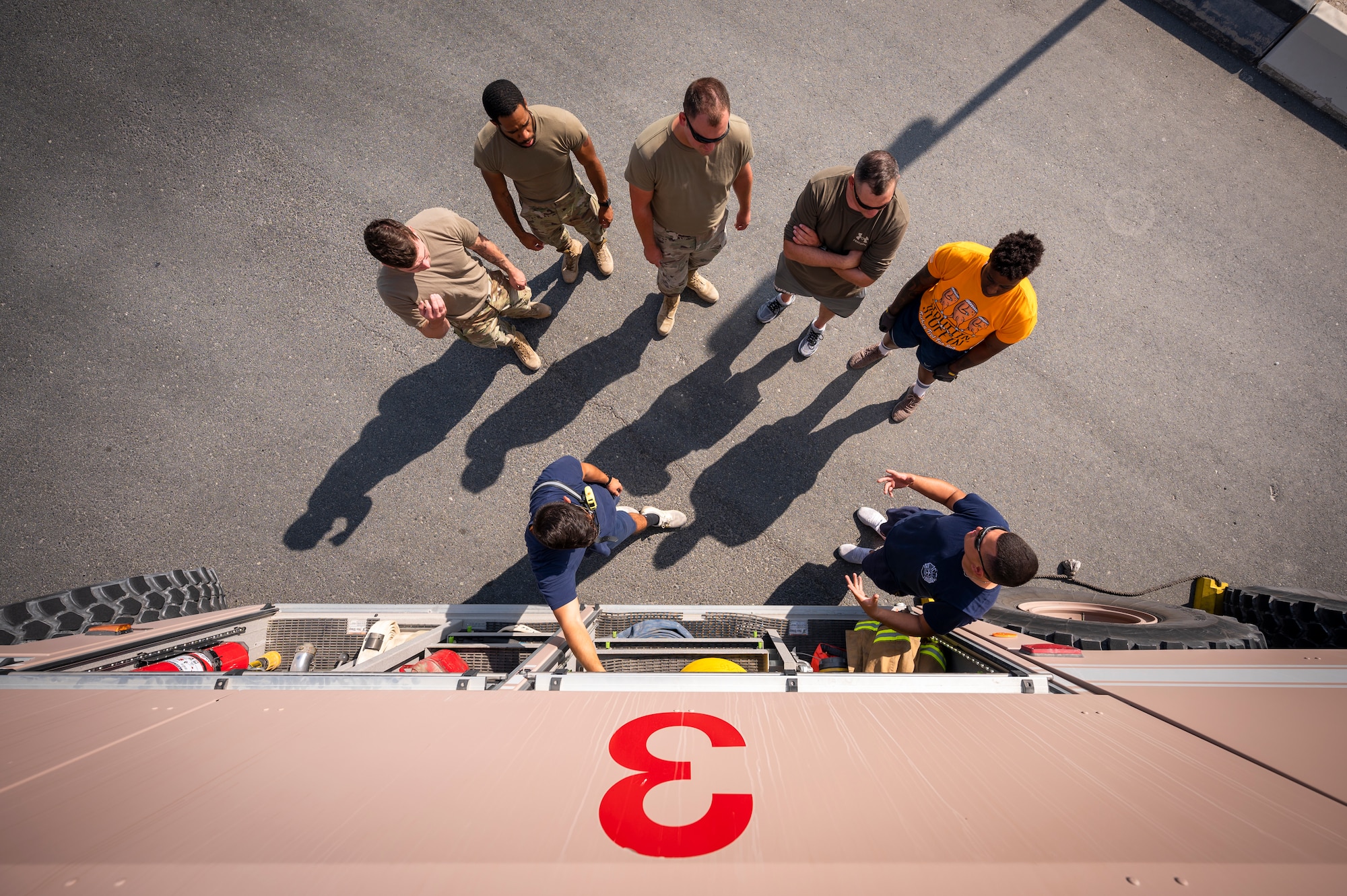 U.S. Air Force firefighters assigned to the 379th Expeditionary Civil Engineer Squadron explain how tools and equipment are stored inside a fire engine to Airmen at Al Udeid Air Base, Qatar, Nov. 27, 2021.