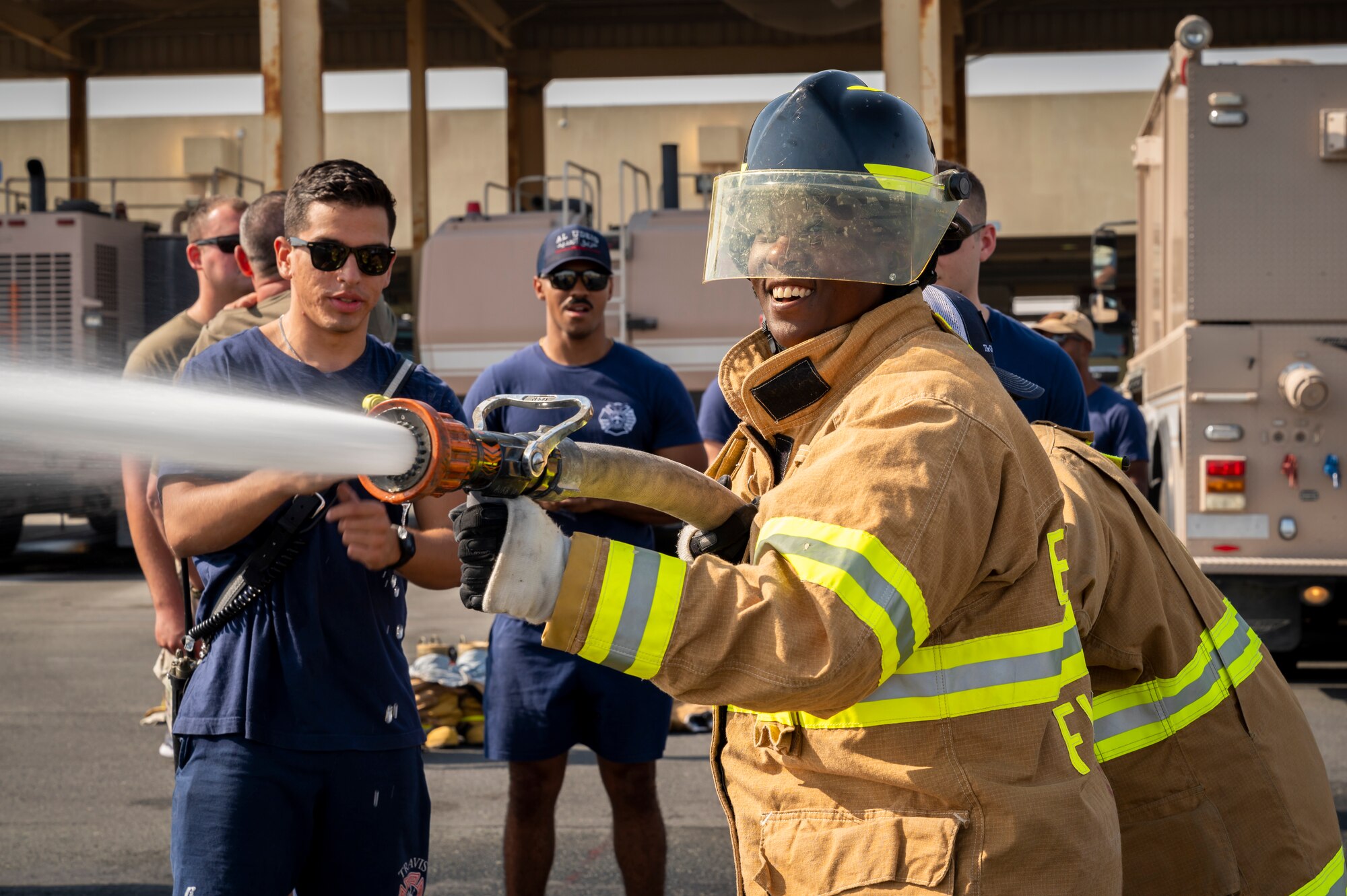 U.S. Air Force Senior Airman Tatiana Allen, 379th Expeditionary Civil Engineer Squadron resource advisor, shoots a firehose during a Firefighter for a Day initiative at Al Udeid Air Base, Qatar, Nov. 27, 2021.