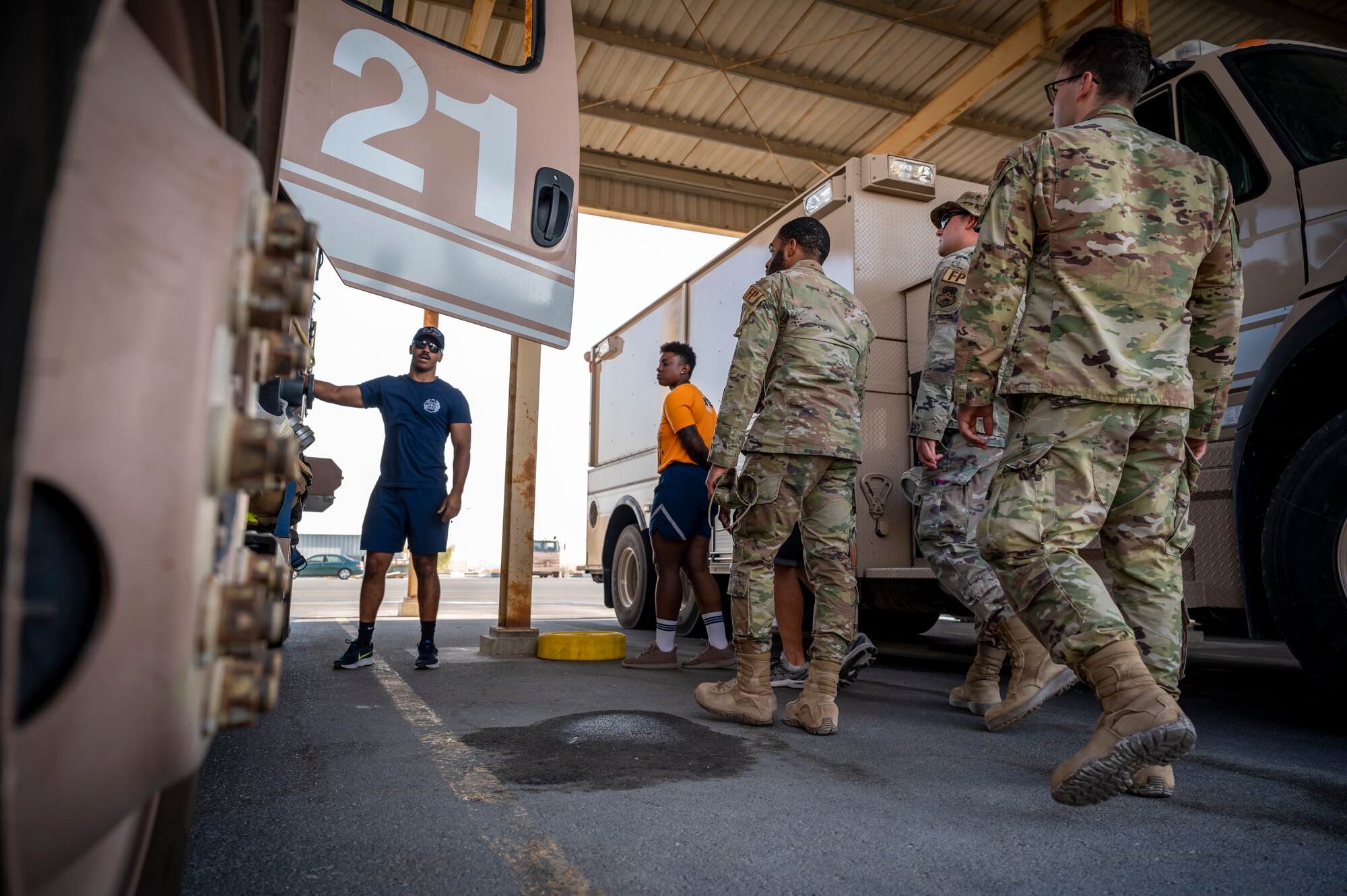 U.S. Air Force Airman 1st Class William Shaw, left, 379th Expeditionary Civil Engineer Squadron firefighter, shows a group of Airmen various components of a fire engine at Al Udeid Air Base, Qatar, Nov. 27, 2021.