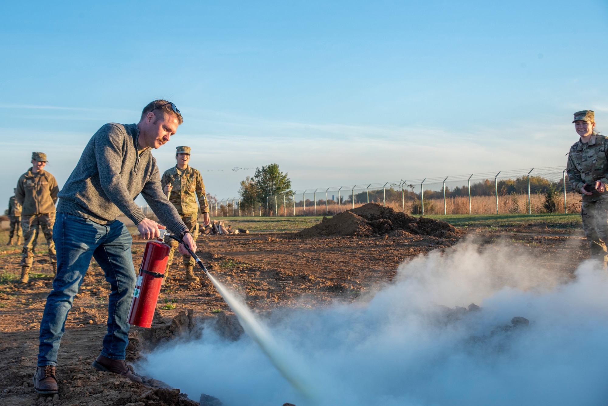 A man uses a fire extinguisher.