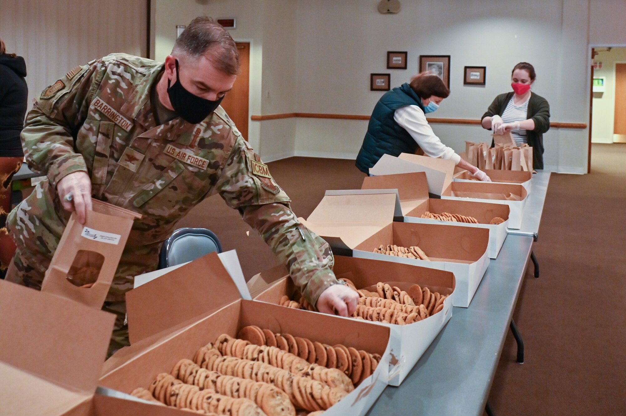 The Air Force Association Cowboy Chapter, Warren Spouses’ Club, Albertsons, base first sergeants, 90th Missile Wing Airman and Family Readiness Center and other community organizations joined together to deliver more than 500 dozen cookies to Airmen and families on F.E. Warren Air Force Base, Wyoming, Dec. 2, 2021. The Cheyenne community came together to spread some holiday cheer for Airmen and families of deployed members for the Air Force Association Cowboy Chapter’s Annual Cookie Drive. (U.S. Air Force photos by Joseph Coslett)