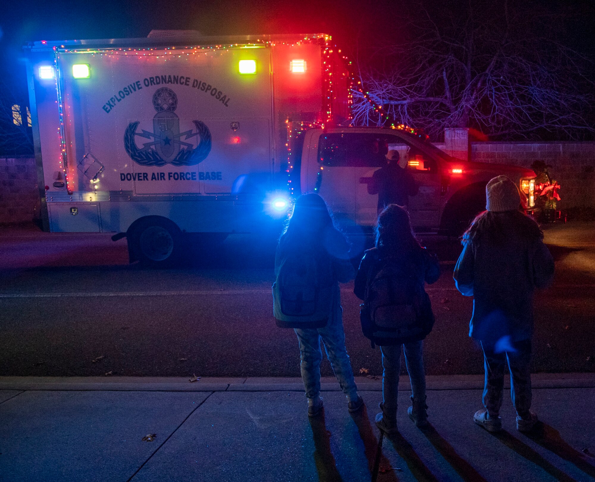 Members of Team Dover watch the 436th Civil Engineer Squadron Explosive Ordnance Disposal truck during the annual Holiday Parade and Tree Lighting Ceremony at Dover Air Force Base, Delaware, Dec. 1, 2021. Numerous units from around base participated in the annual parade to help bring holiday cheer throughout base housing. (U.S. Air Force photo by Tech. Sgt. Nicole Leidholm)