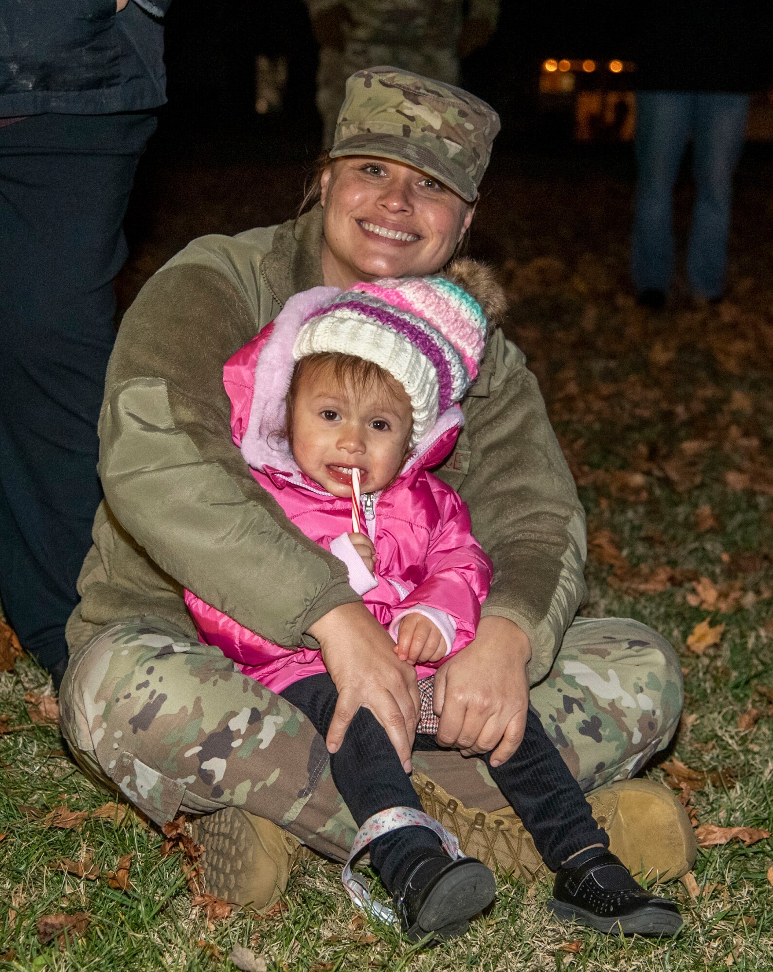Tech. Sgt. Heather Truitt, 436th Civil Engineer Squadron workforce management craftsman, and her daughter, Bonnie, listen to the Dover Air Force Base Middle School Choir and True Blue during the annual Holiday Parade and Tree Lighting Ceremony at Dover AFB, Delaware, Dec. 1, 2021. The annual ceremony marks the start of the holiday season at Dover AFB. (U.S. Air Force photo by Tech. Sgt. Nicole Leidholm)