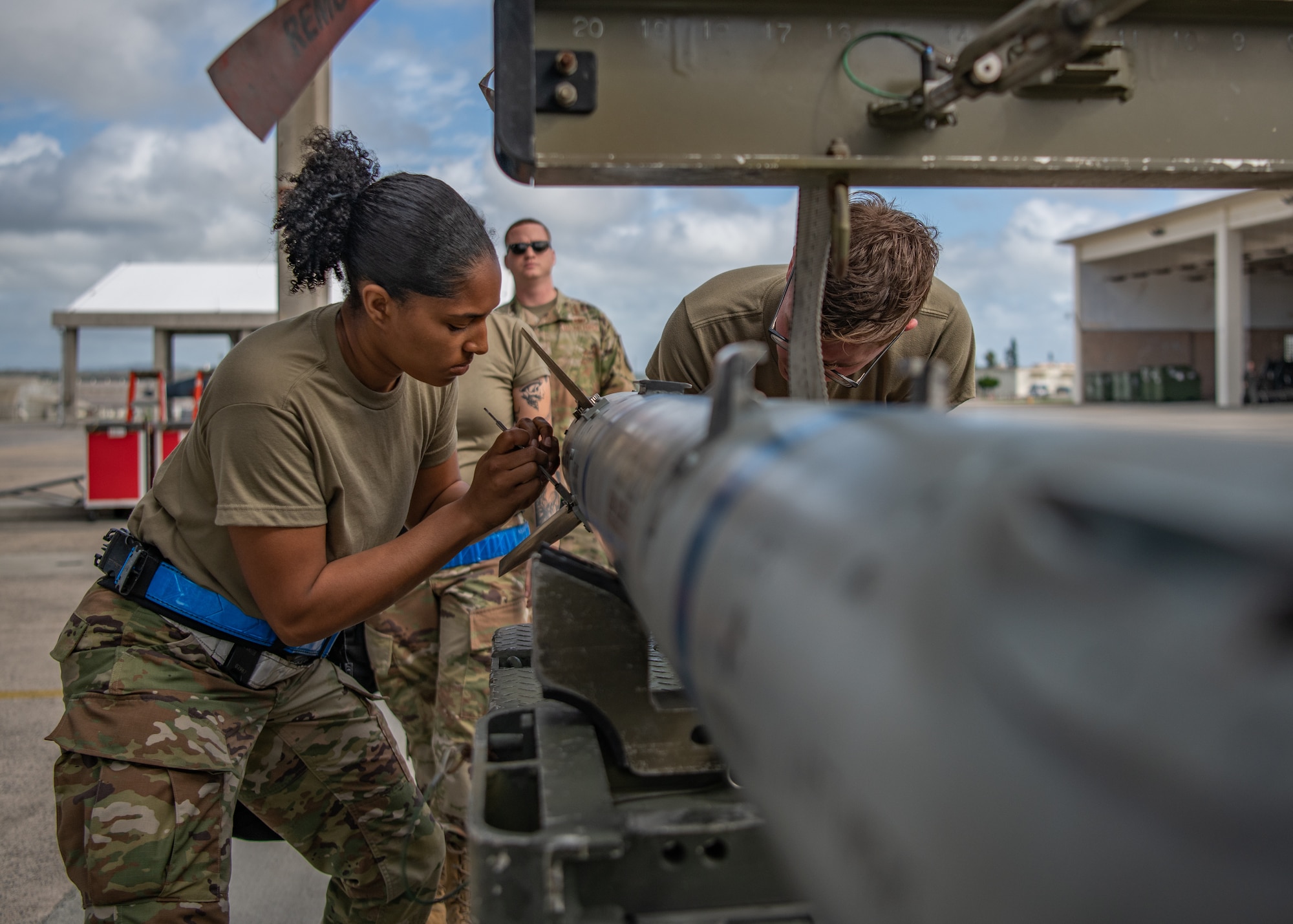Two Airmen work together to load munitions on an F-15C Eagle